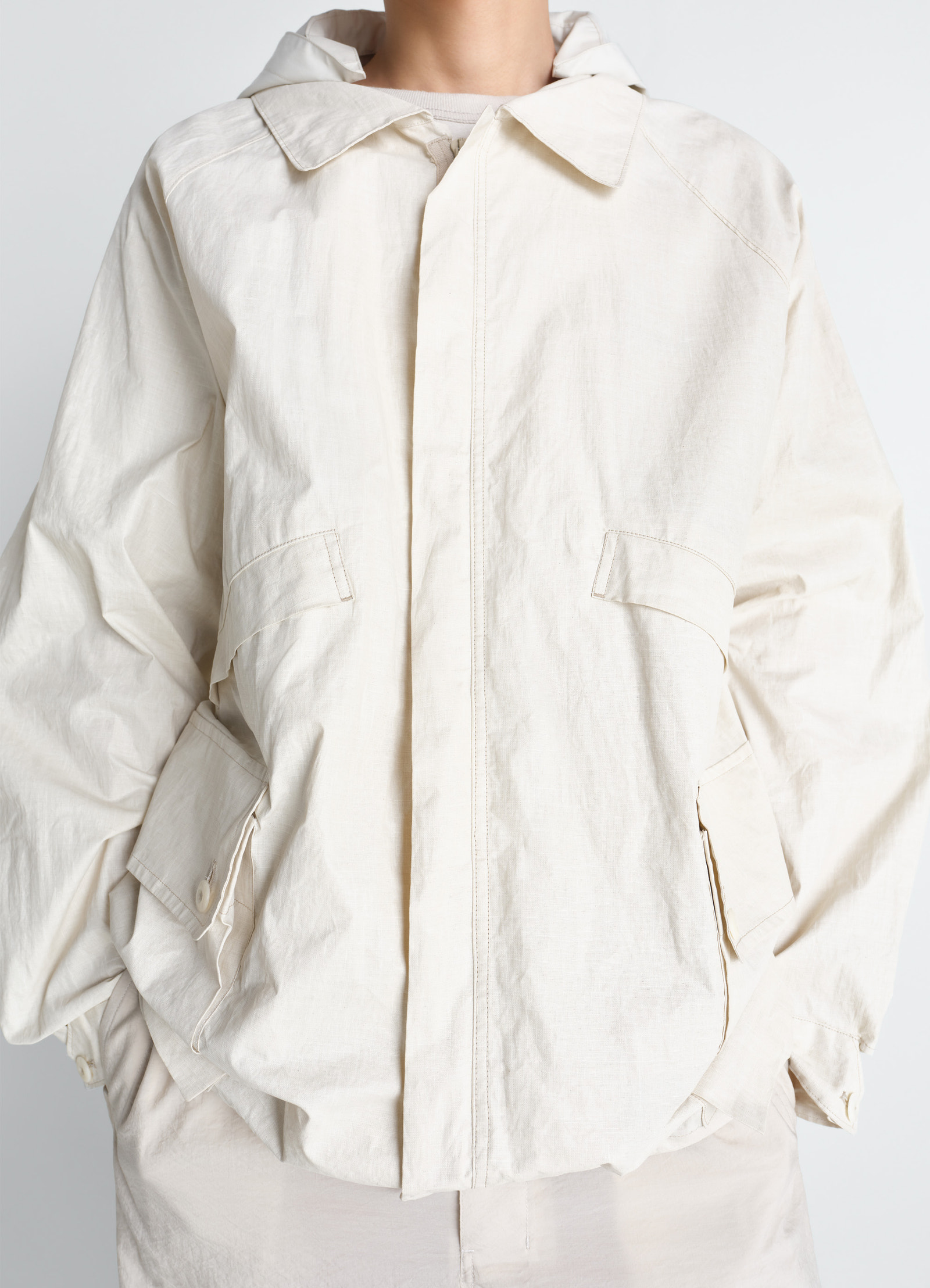 Lemaire rain jacket in coated technical linen, model shot, close-up front view boxy pockets, collar focus