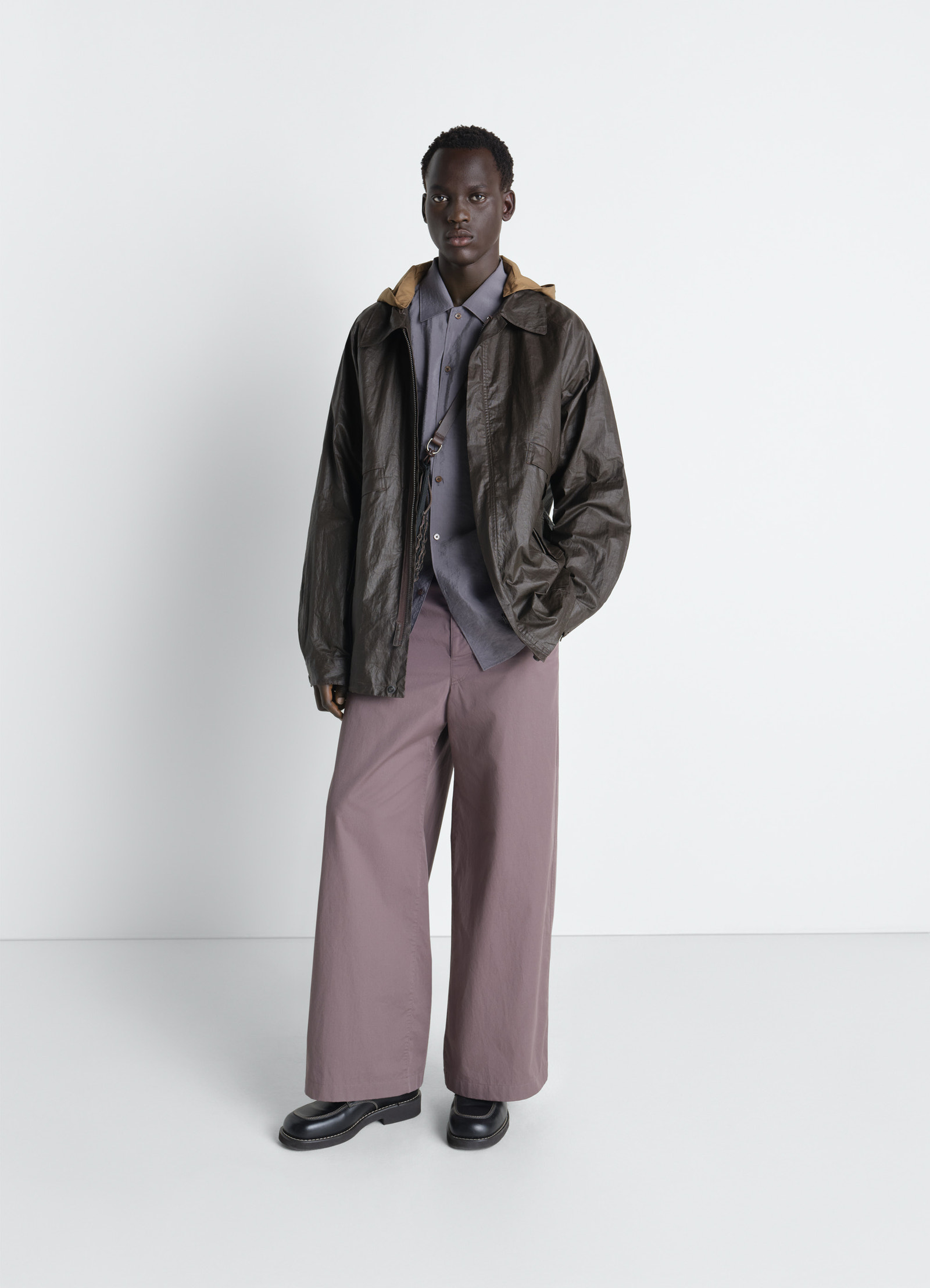 Lemaire rain jacket in coated technical linen, model shot, three-quarter view detachable hood, relaxed fit
