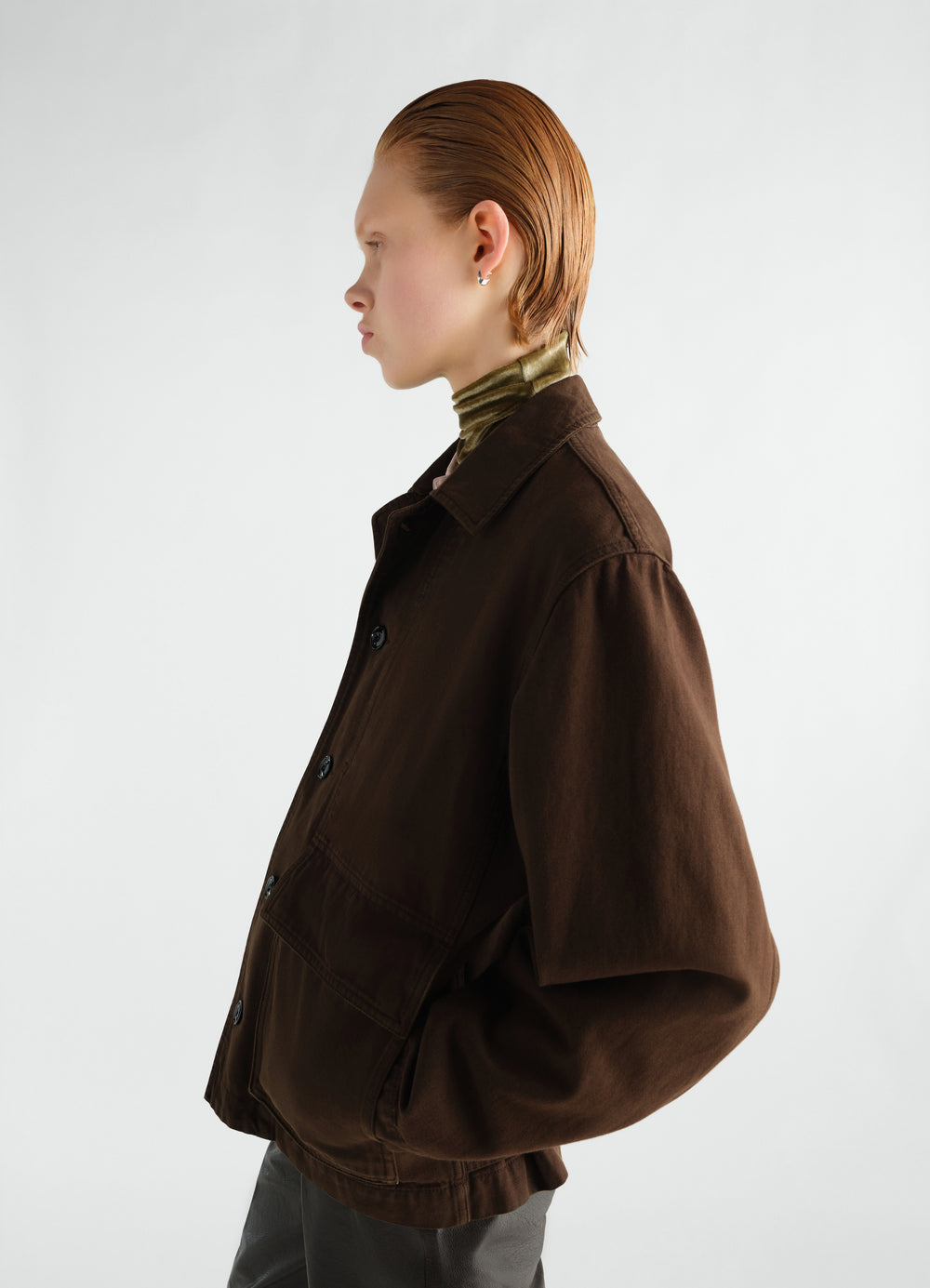Boxy brown garment-dyed twill jacket by LEMAIRE worn by model side view with pockets and buttons