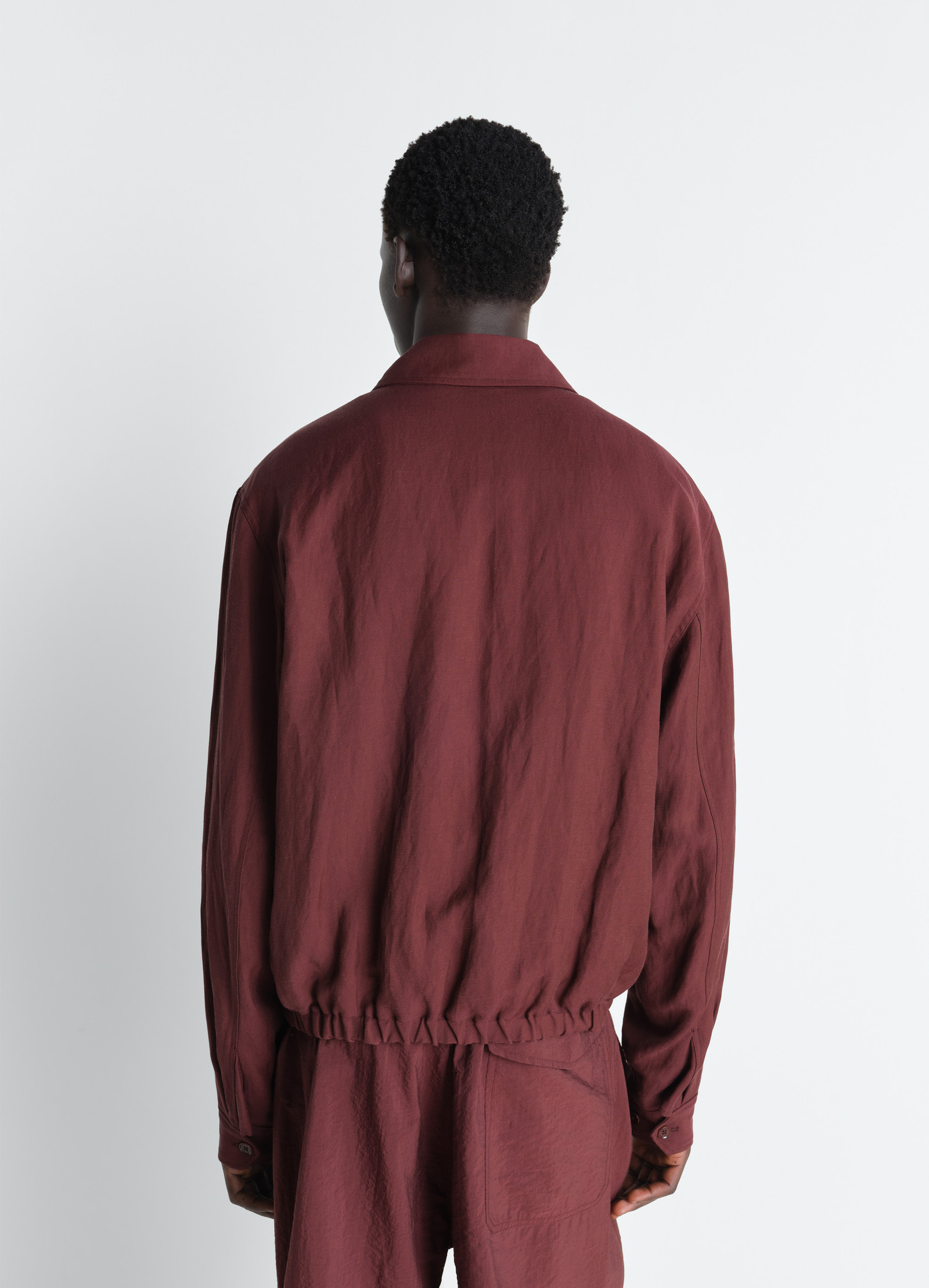 Short blouson in viscose linen gabardine, model shot, back three-quarter view elastic waistband