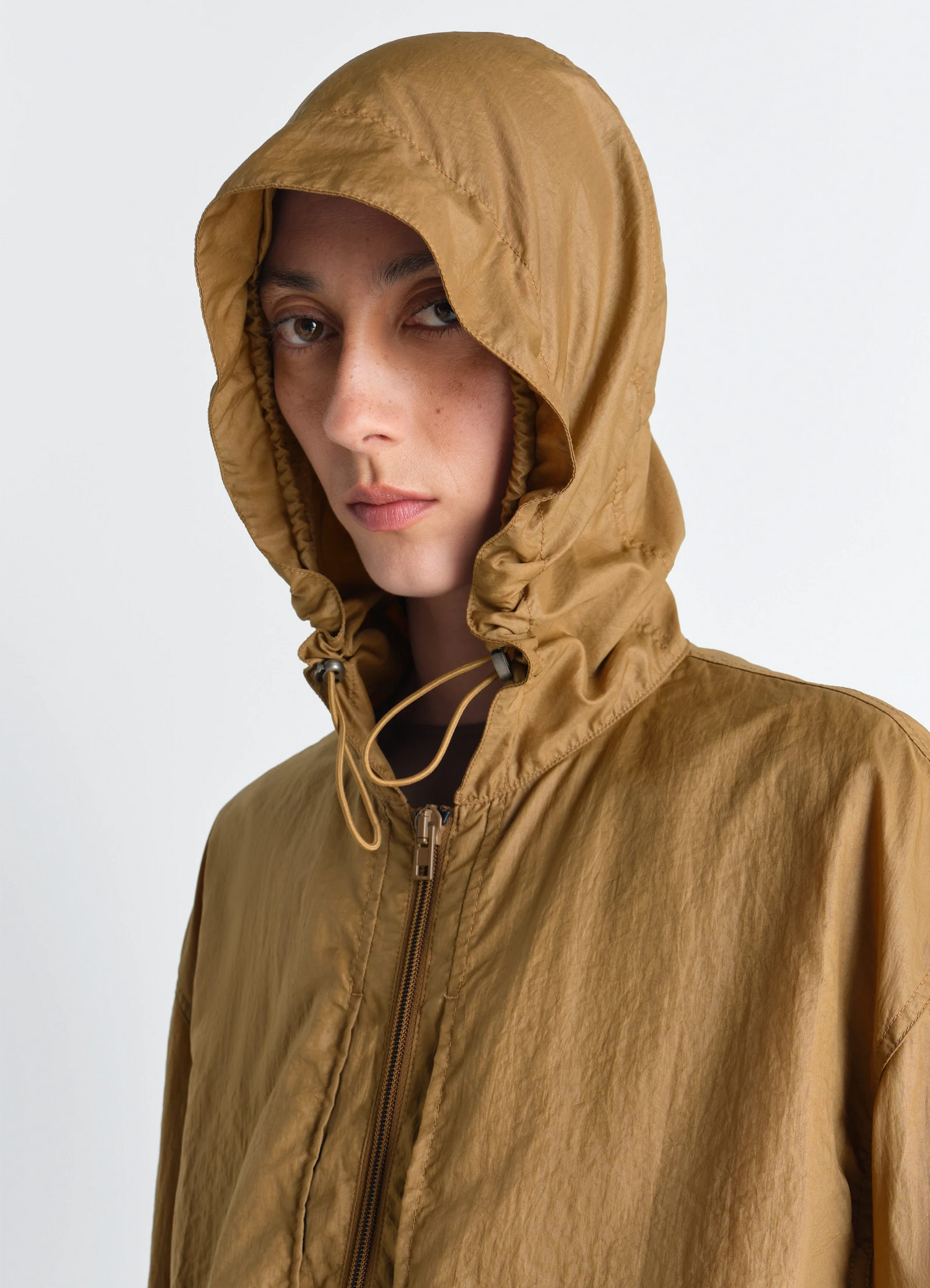 Windbreaker in light nylon in light nylon, model shot, close-up view zipper front, adjustable hood