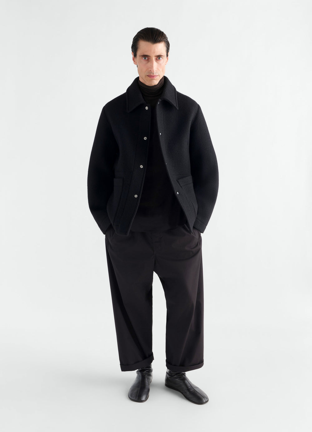 Utility jacket in black heavy wool cloth LEMAIRE worn by a model front view with pockets and snap buttons