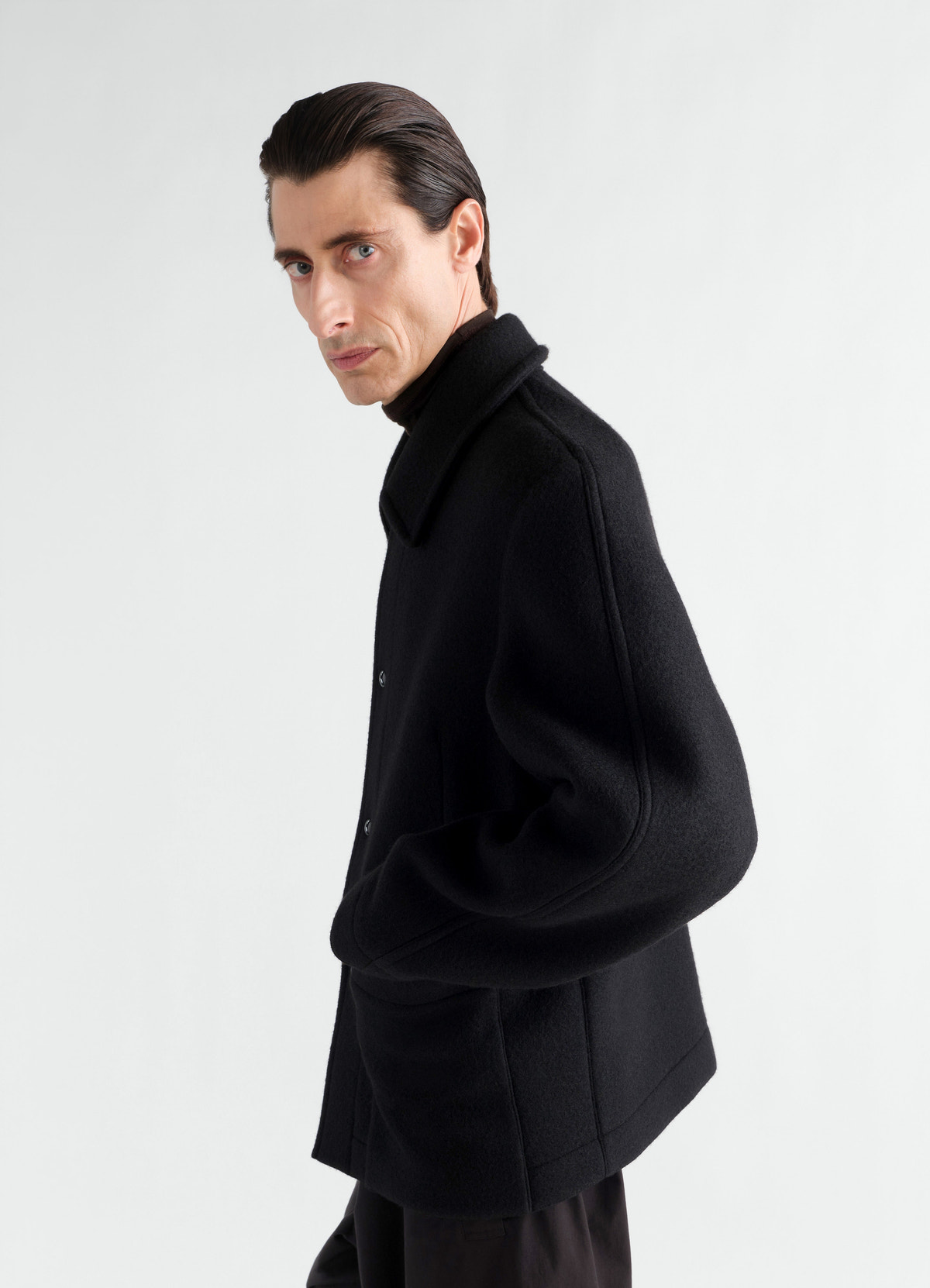 Utility jacket in black heavy wool cloth lemaire worn by model side view with collar and pockets