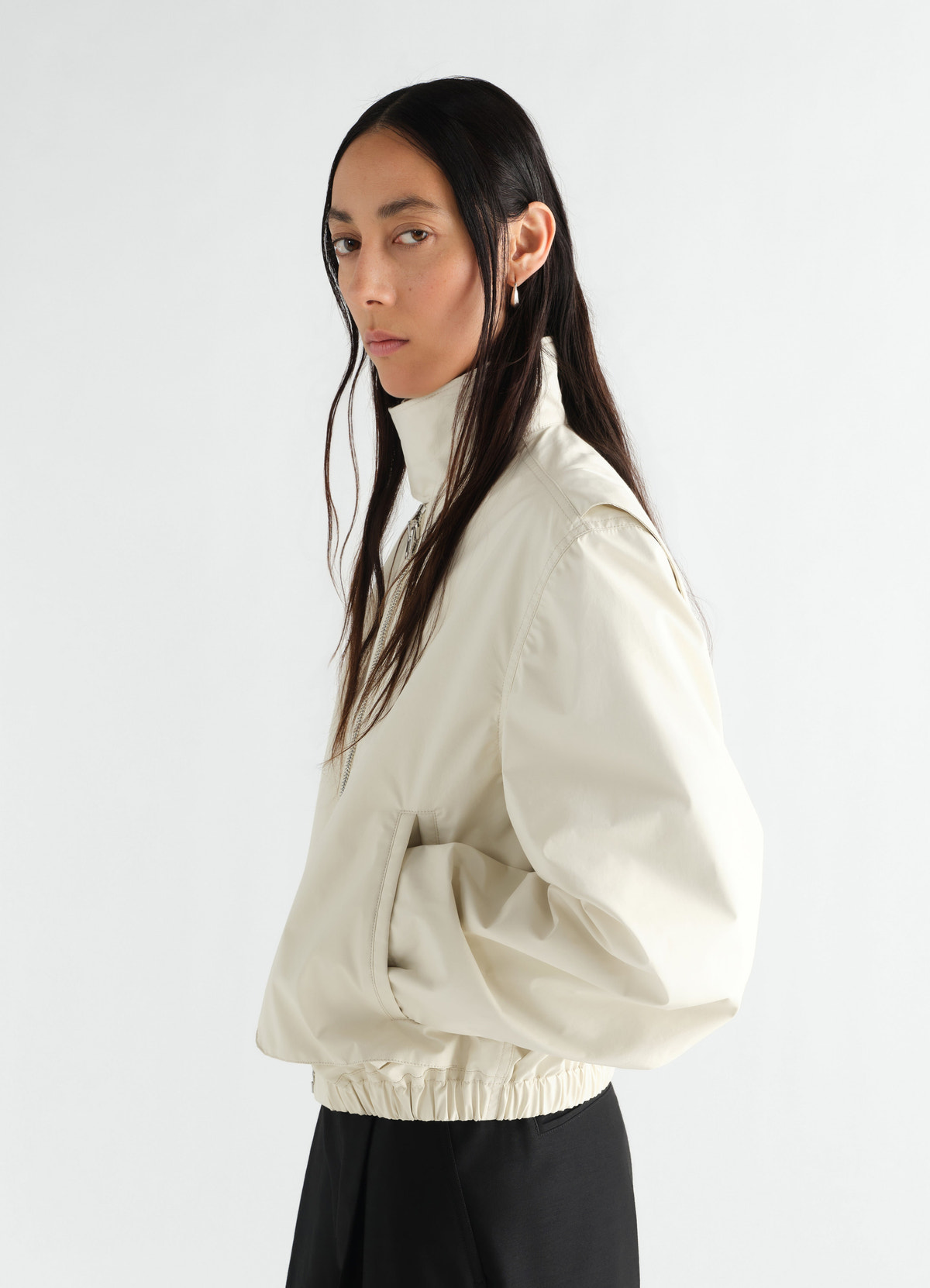 Zipped beige waterproof cotton blouson with high collar by lemaire worn by model side view