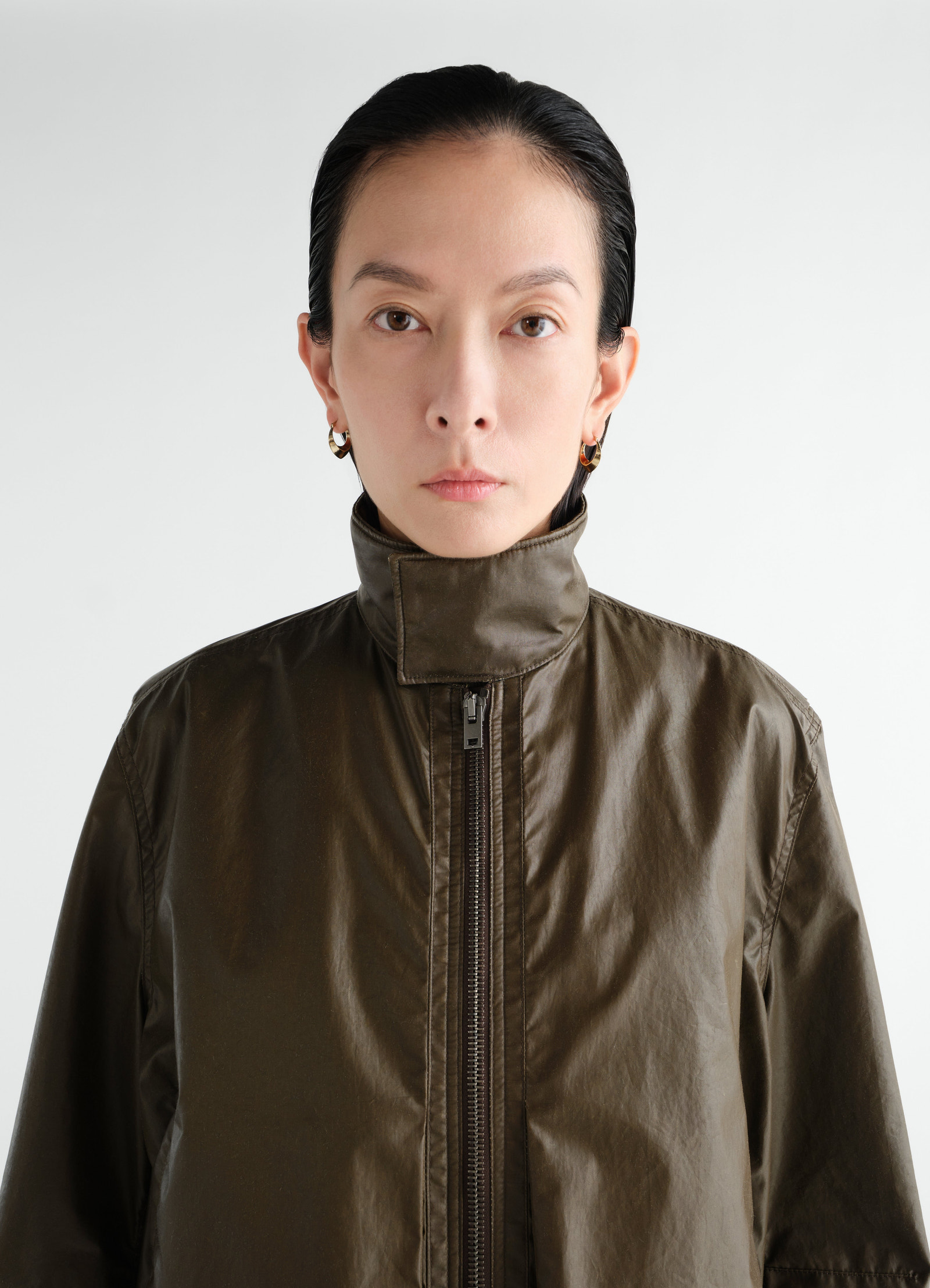 Zipped waterproof cotton blouson in olive green by lemaire worn by model front view close-up