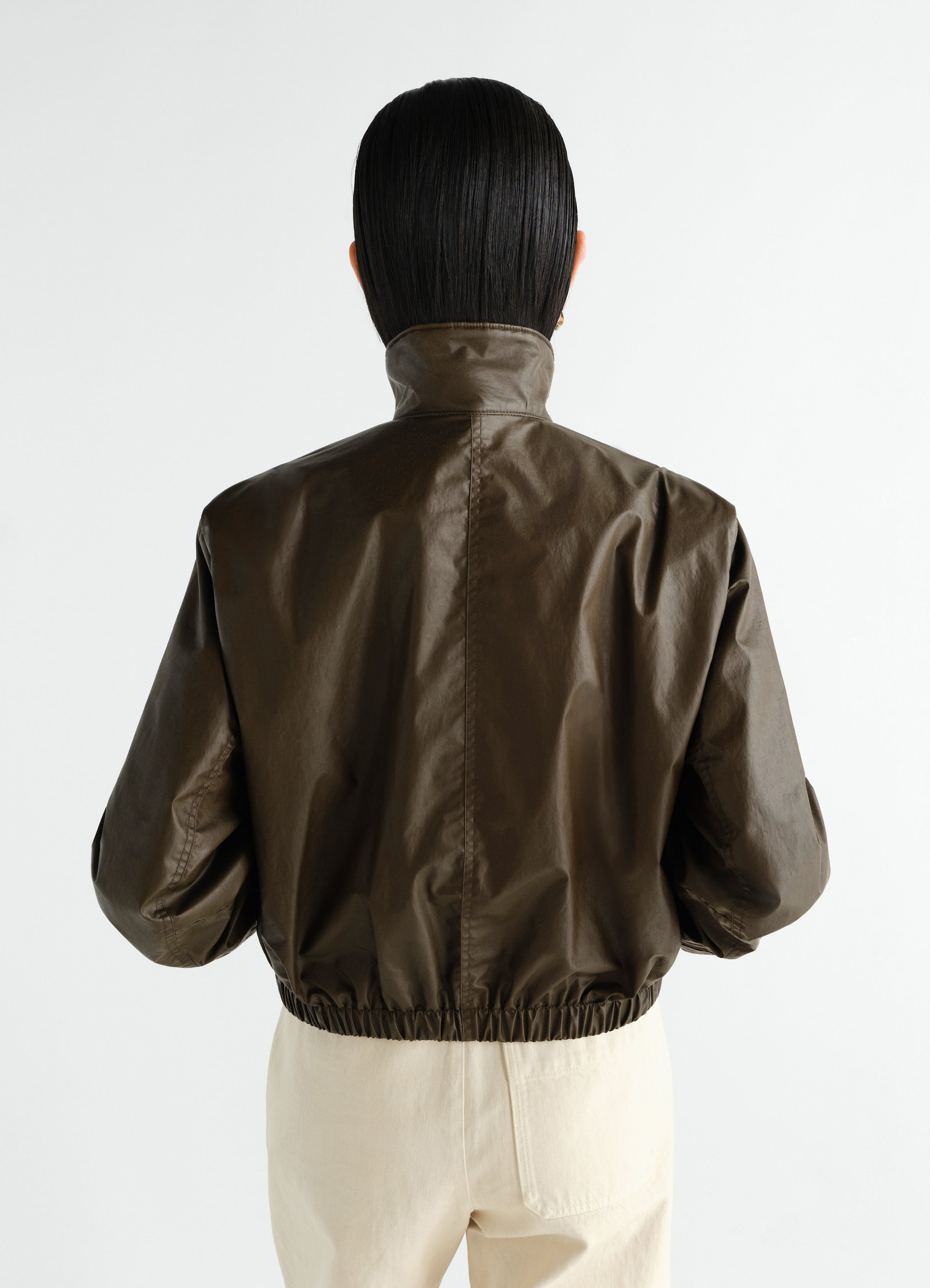 Zipped blouson in waterproof brown cotton with high collar, elastic hem, worn by model back view lemaire