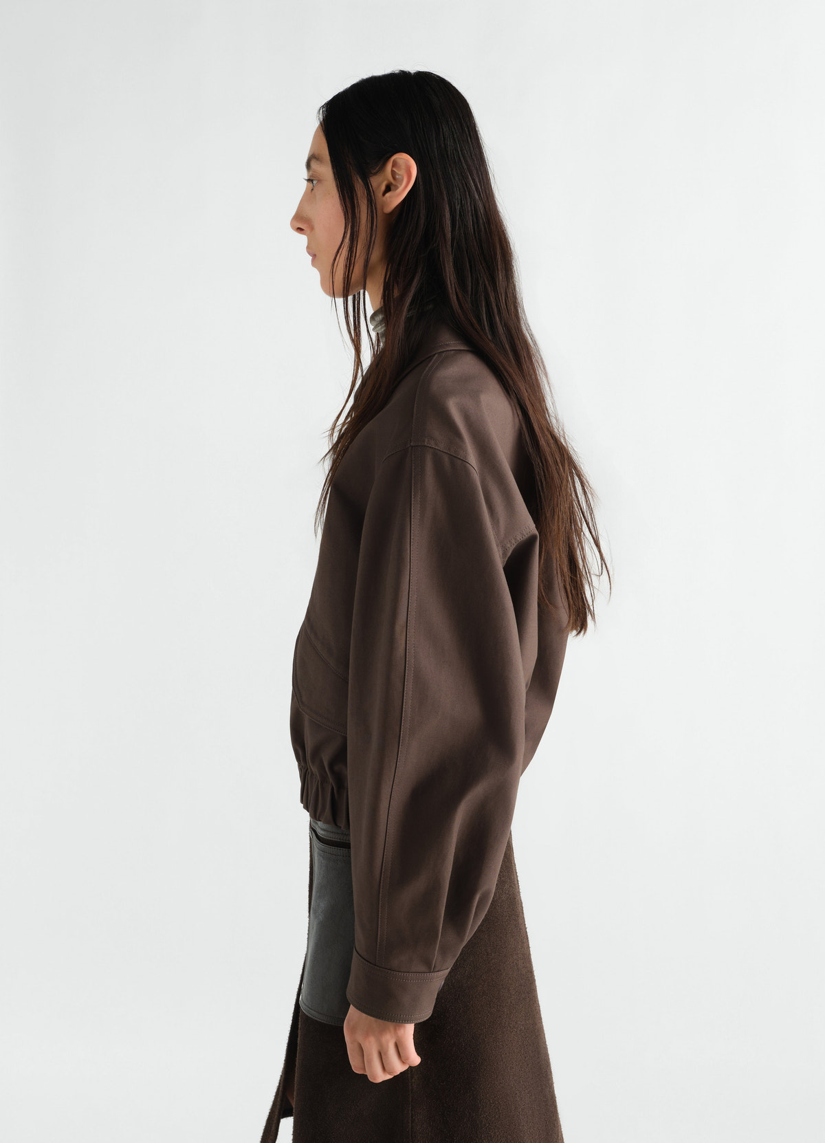 Short blouson in heavy brown cotton twill by lemaire worn by model side view on plain white background