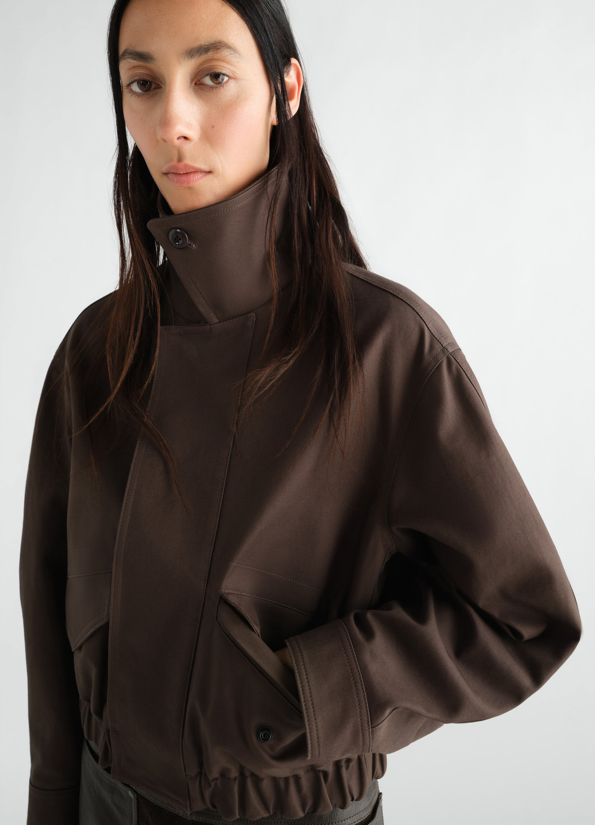 Short brown heavy cotton twill blouson with high collar and elastic hem worn by model lemaire