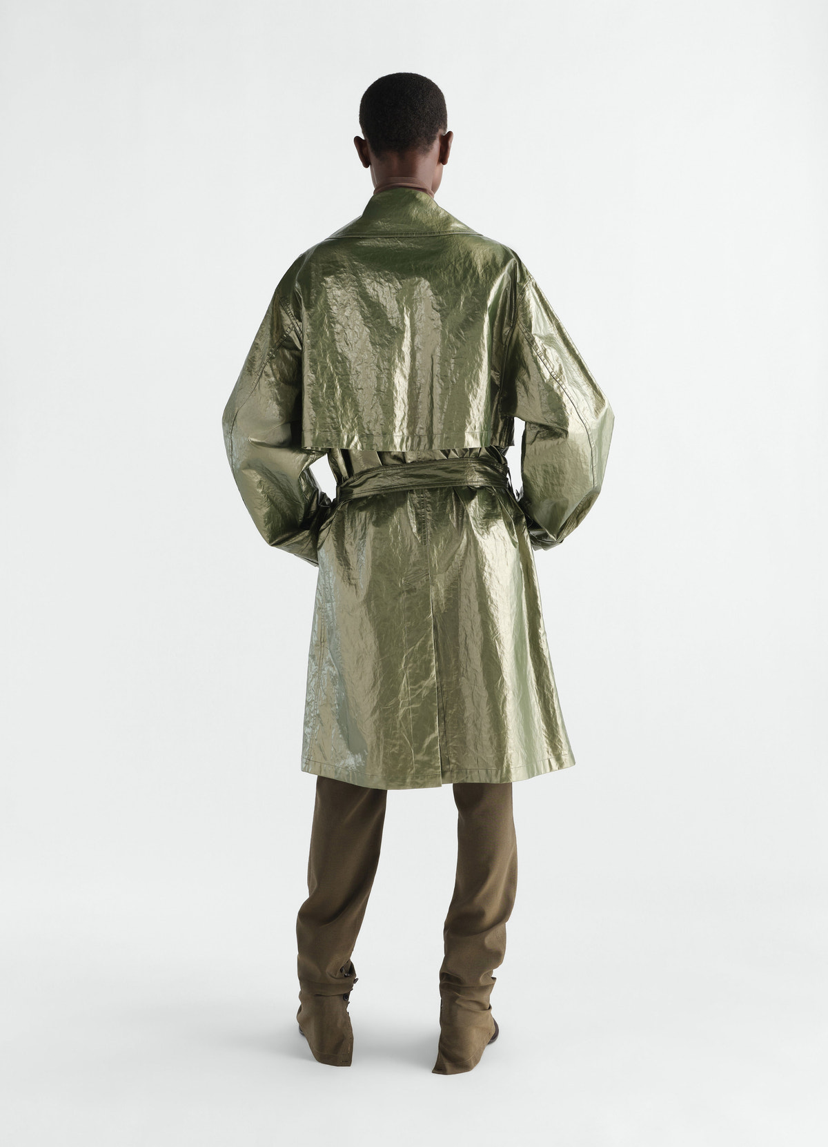 Trench coat in shiny olive water-repellent linen by lemaire worn by model back view with belt detail