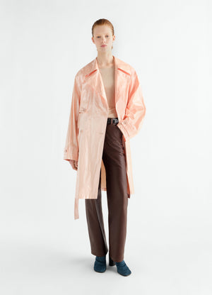 Trench en lin enduit brillant déperlant, coloris pêche, porté par un mannequin, vue de face