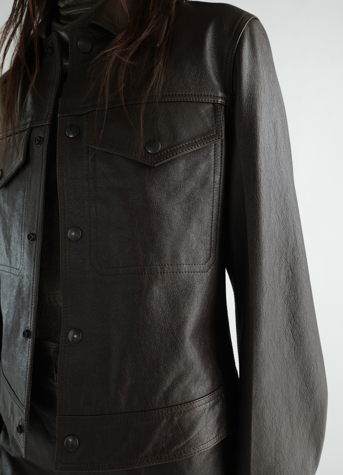 Trucker jacket in glossy brown leather by lemaire worn by model showing front detail close-up