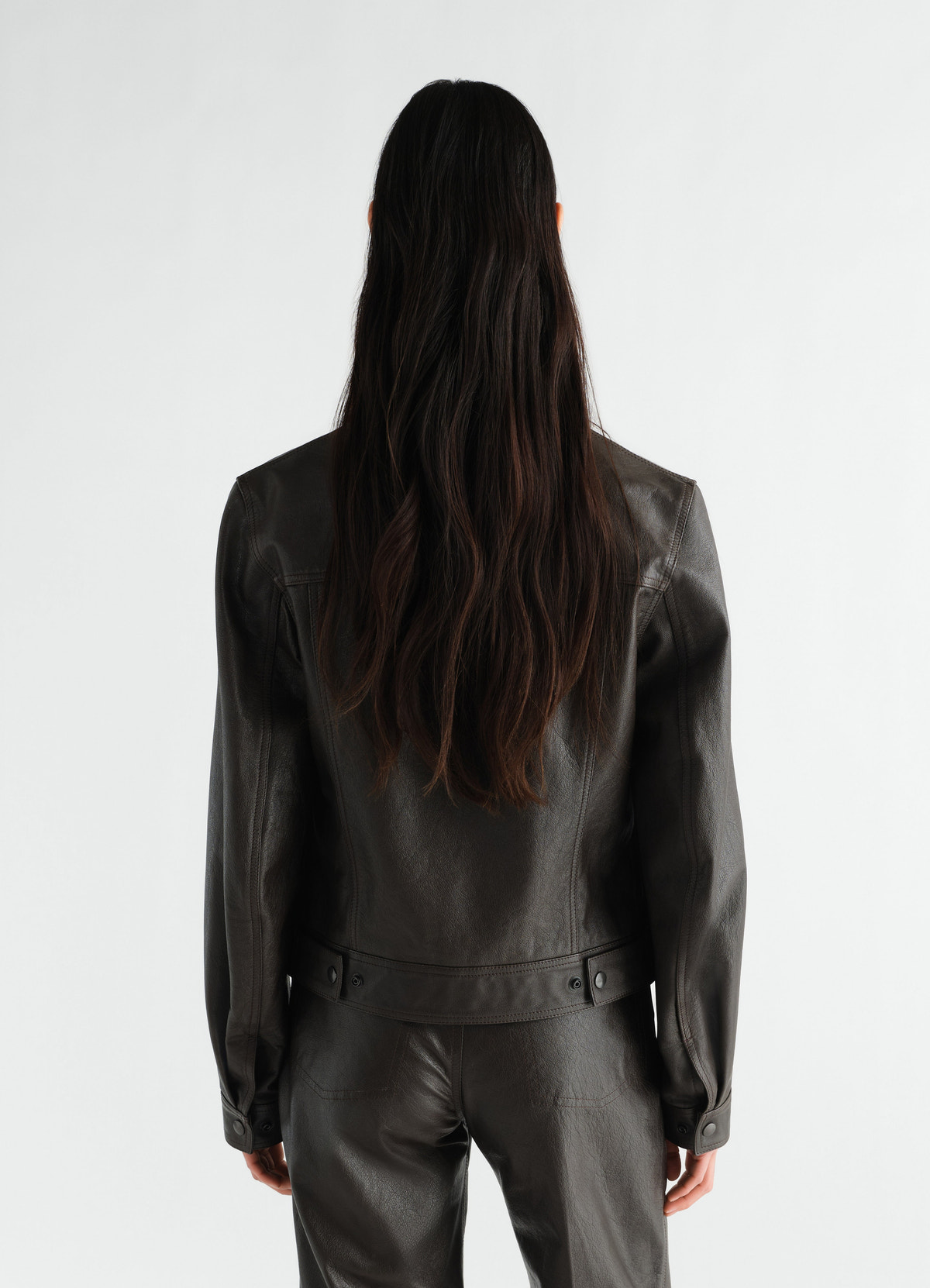 Trucker jacket in glossy dark brown leather lemaire back view worn by model