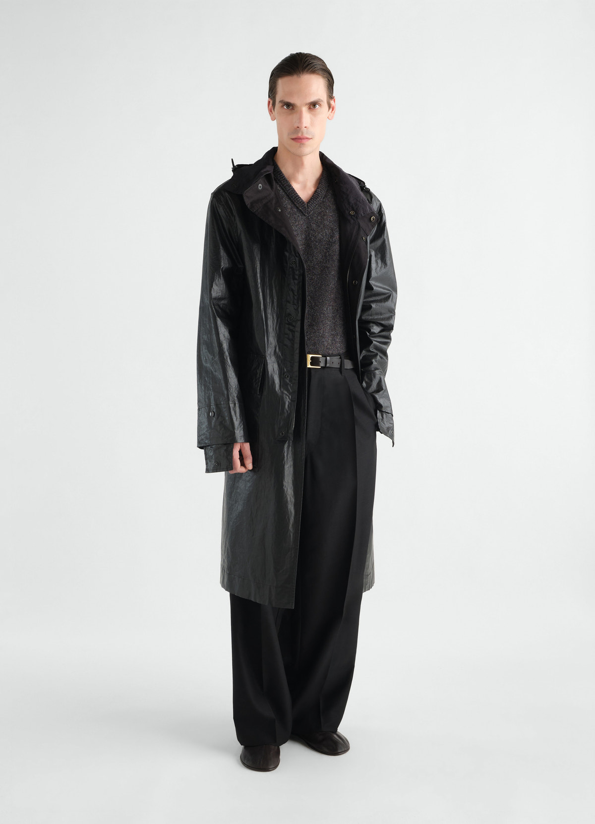 Long black coated linen cotton blend raincoat by lemaire worn by model front view