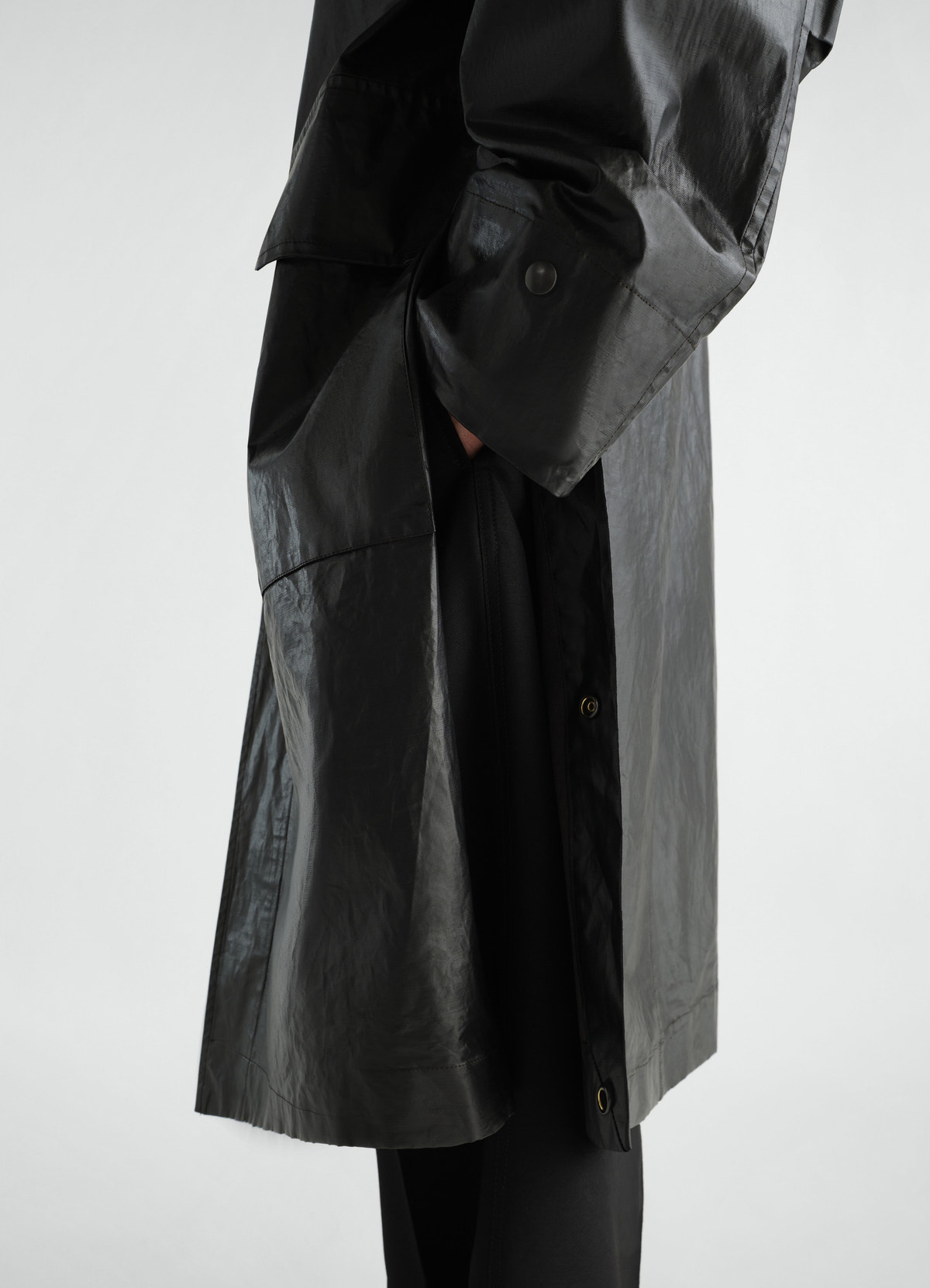 Long black coated linen cotton blend raincoat by lemaire side detail worn by model