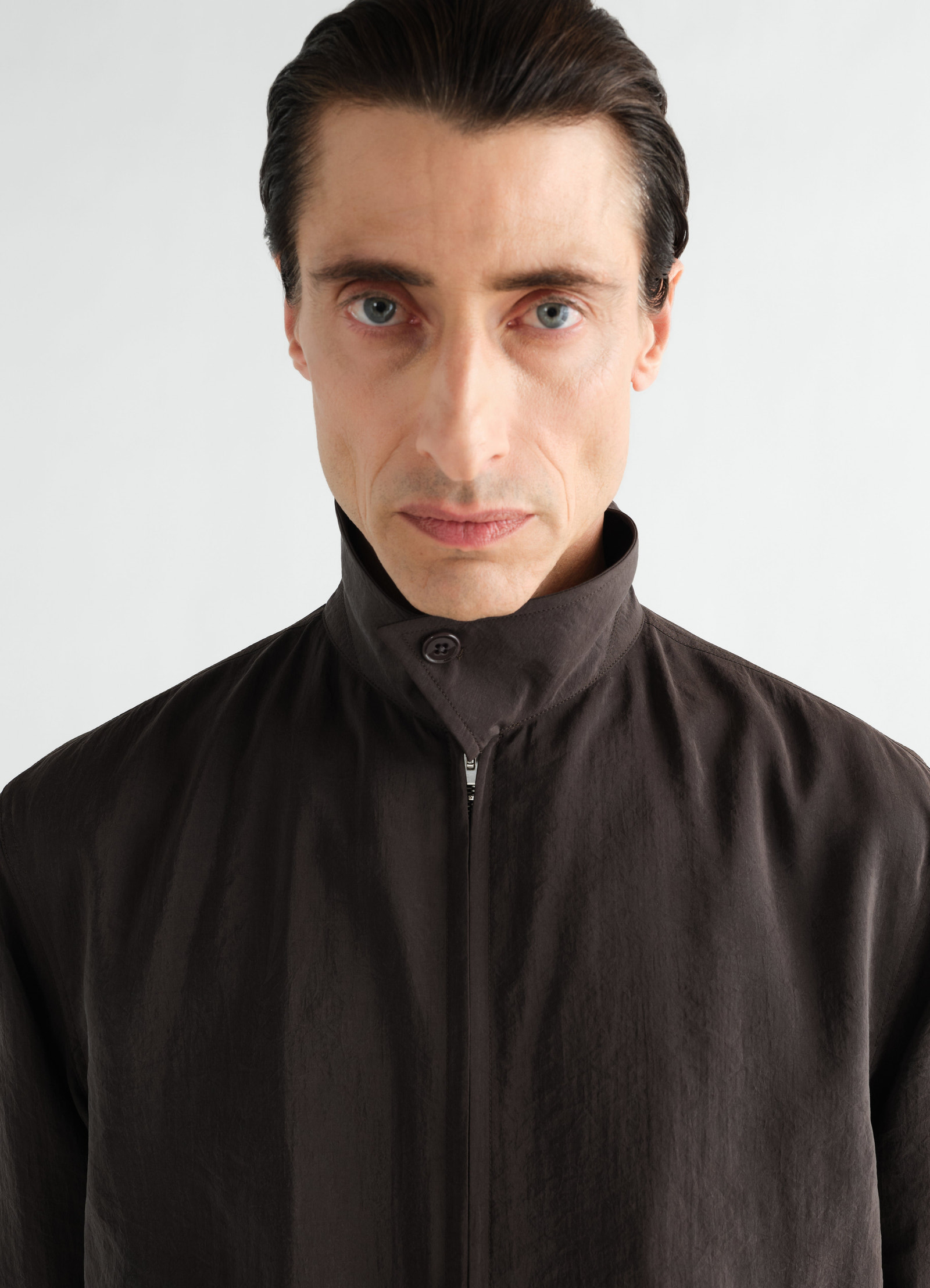 Light brown dry silk zipped blouson with high collar by lemaire worn by model front close-up