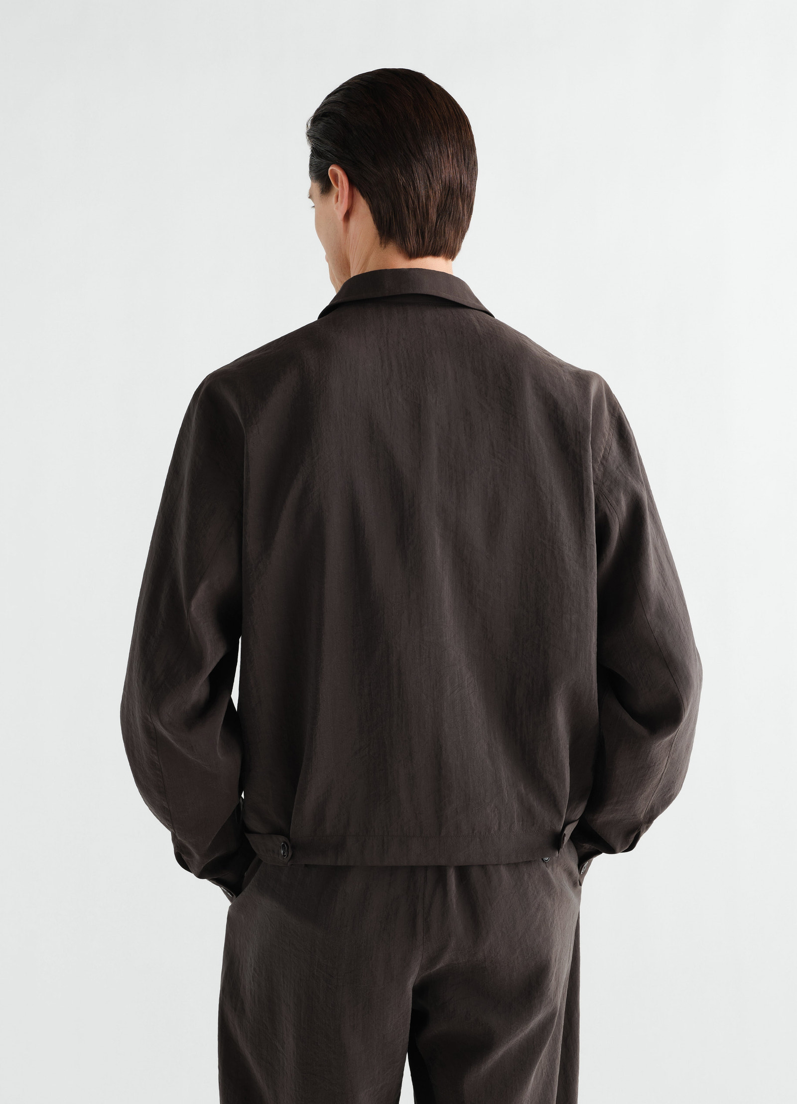Light zipped blouson in dry silk dark brown by lemaire back view worn by a model