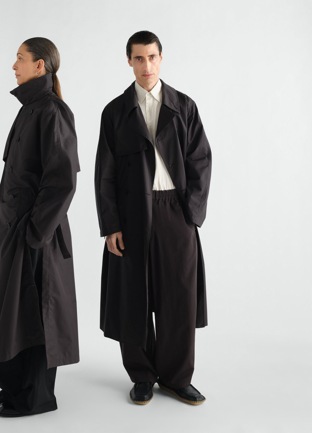 Light black water-repellent cotton gabardine trench coat by lemaire worn by front and side models