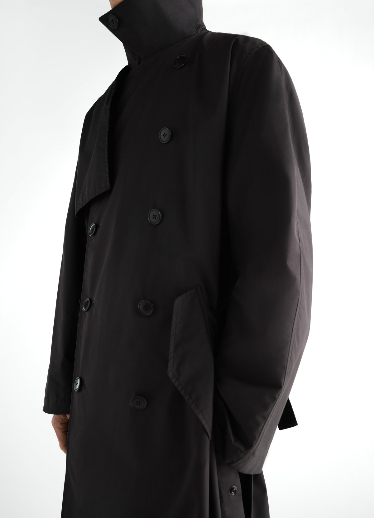 Light black cotton gabardine trench coat by lemaire worn by model front close-up with button details