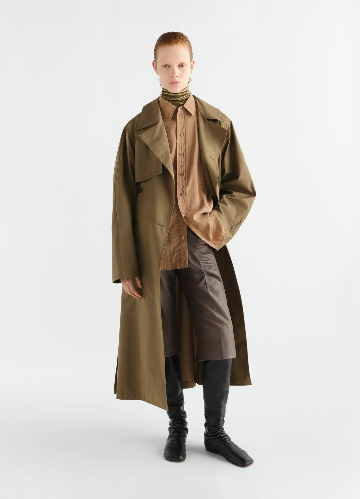 Light olive water-repellent cotton trench coat by lemaire worn by model with brown shirt and black boots