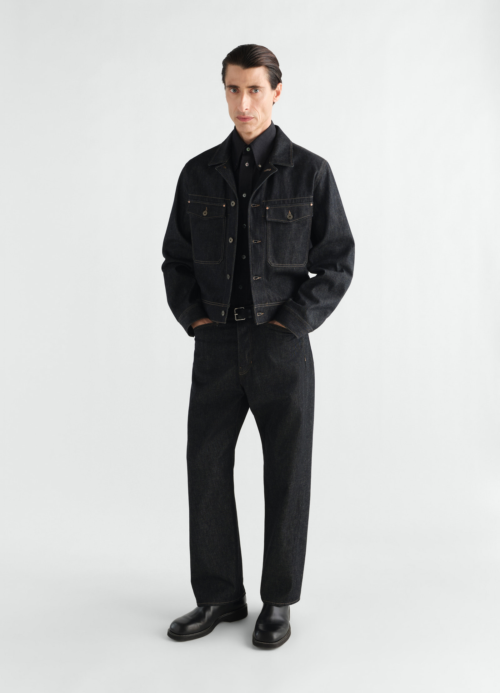 Trucker jacket in black denim with chest pockets worn by a model lemaire styled look front view