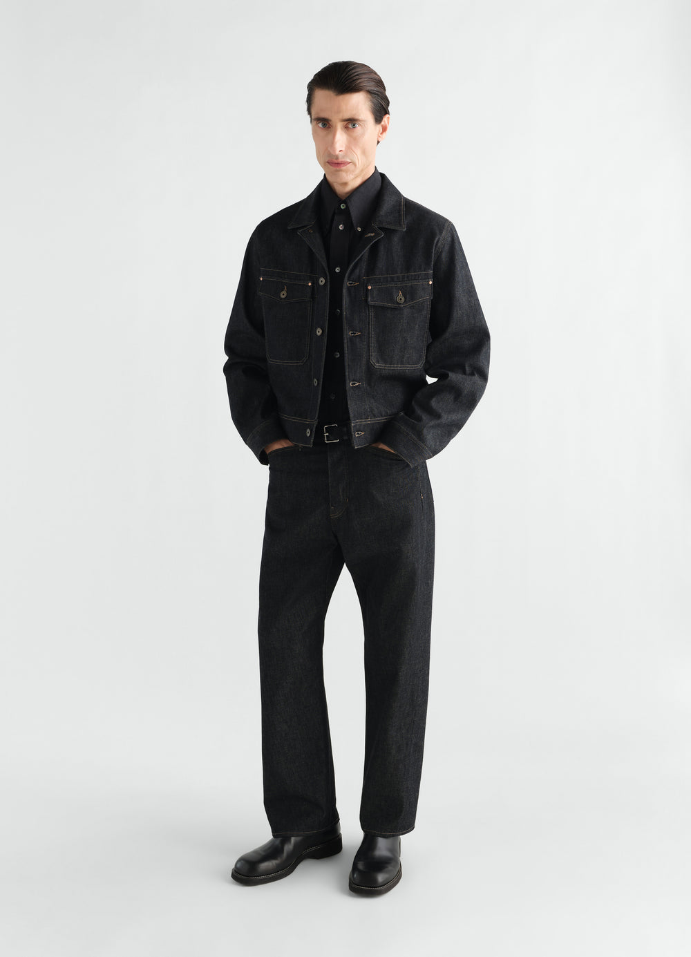 Trucker jacket in black denim with chest pockets worn by a model LEMAIRE styled look front view