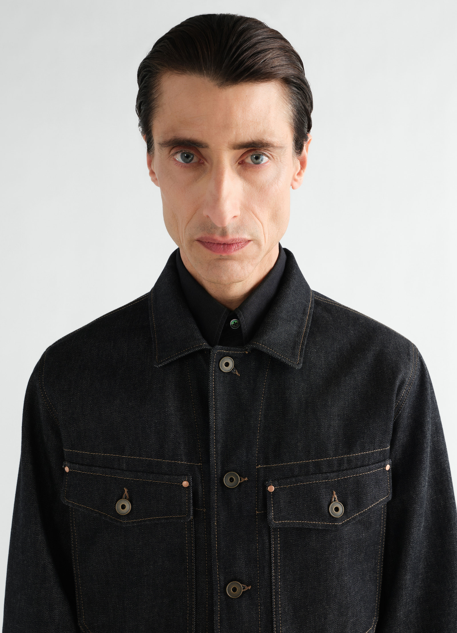 Trucker jacket in slate denim with contrast stitching worn by model front view lemaire
