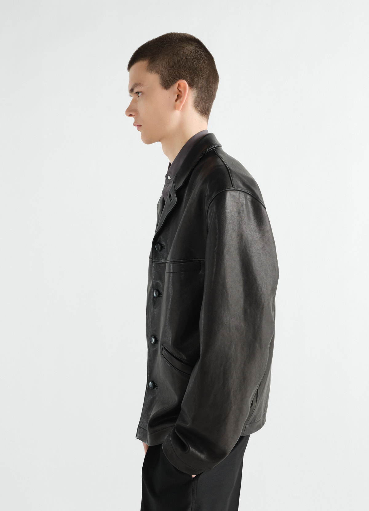 Veste à simple boutonnage en cuir d'agneau grainé, coloris noir, porté par un mannequin, vue de profil, texture visible