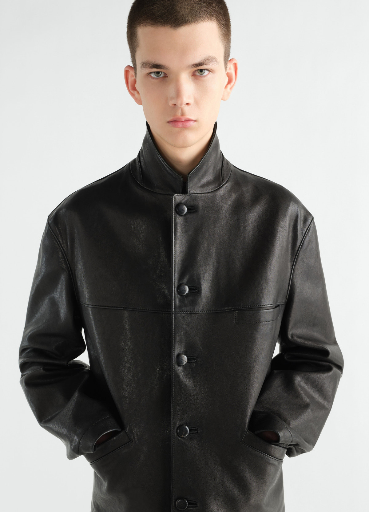 Veste à simple boutonnage en cuir d'agneau grainé, coloris noir, porté par un mannequin, vue de face, poches visibles, texture visible, col visible