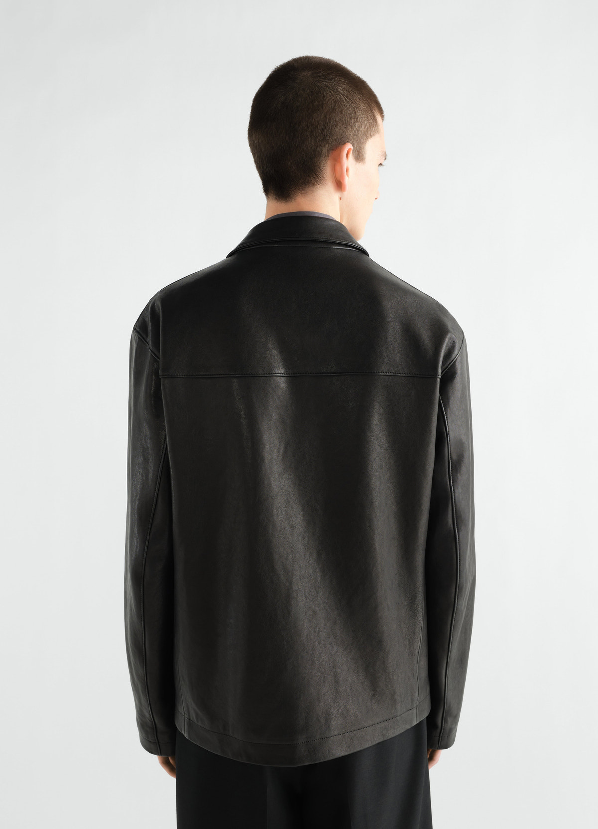 Veste à simple boutonnage en cuir d'agneau grainé, coloris noir, porté par un mannequin, vue de dos, texture visible