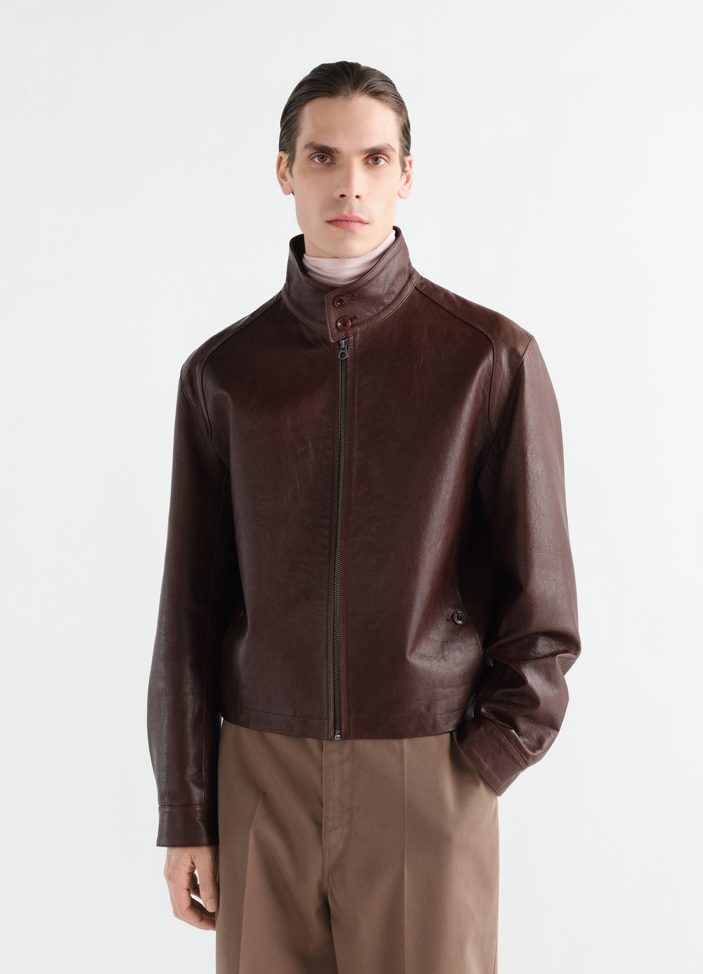 HARRINGTON-BLOUSON AUS GLÄNZENDEM RINDSLEDER, in Dunkelbraun, von einem Model getragen, Vorderansicht, Reißverschluss sichtbar, Kragen sichtbar