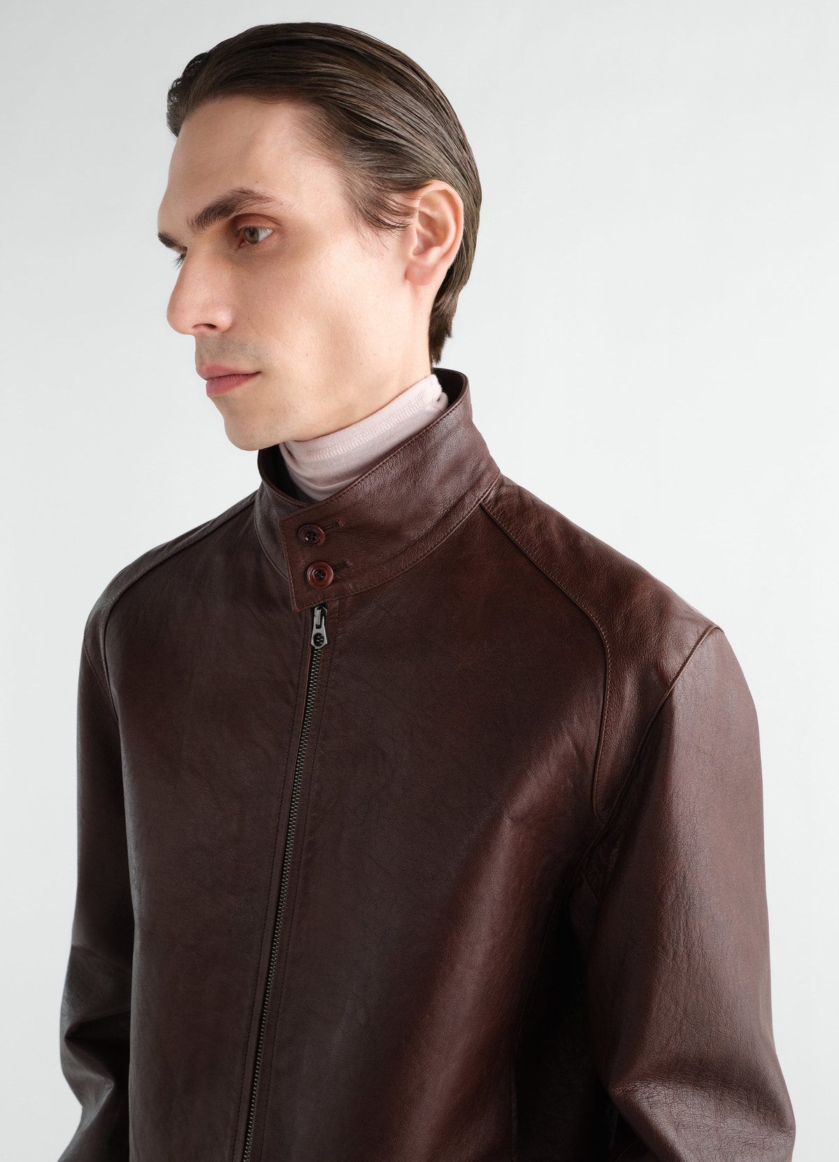 Harrington-blouson aus glänzendem rindsleder, in braun, von einem model getragen, nahaufnahme von vorn, knöpfe sichtbar, kragen sichtbar