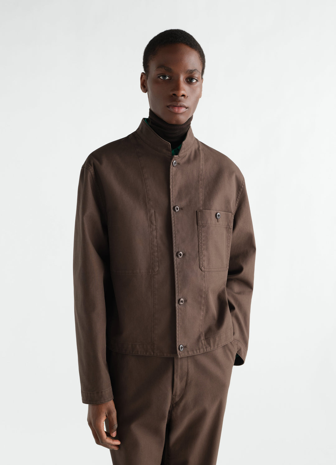 Stand-collar brown heavy cotton twill jacket by LEMAIRE worn by model front view with pocket detail
