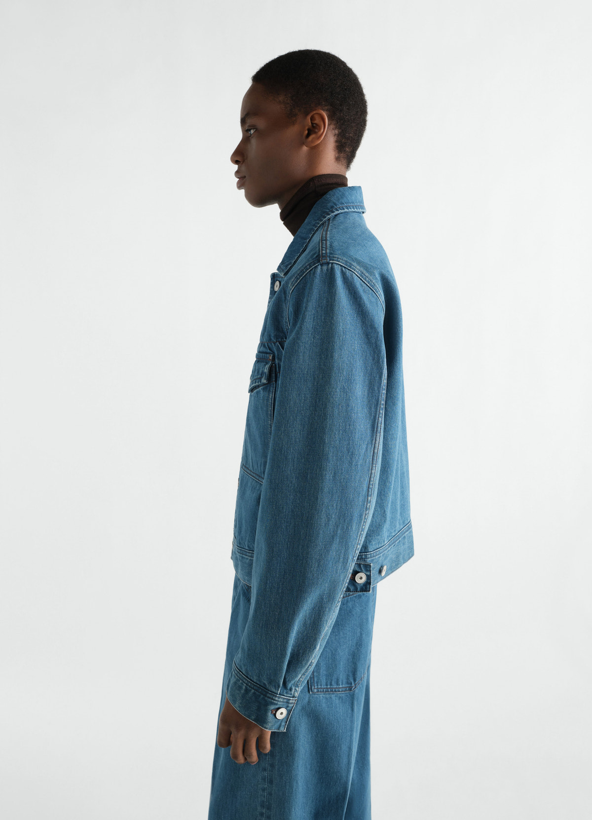 Trucker jacket indigo selvedge denim worn by a model side view lemaire