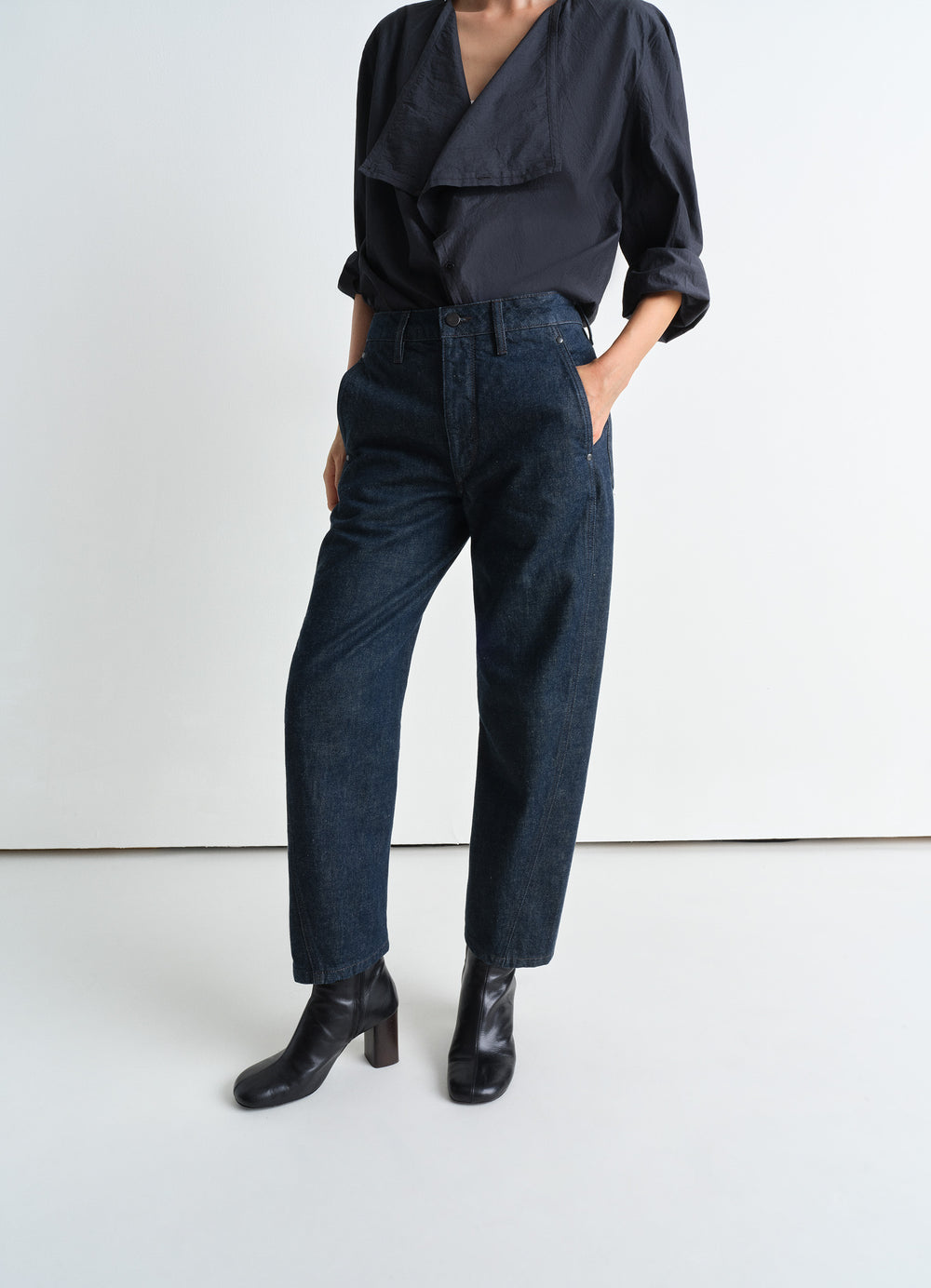 Lemaire Twisted Pants in Deep Indigo Heavy Denim, model shot, porte side view twisted seams