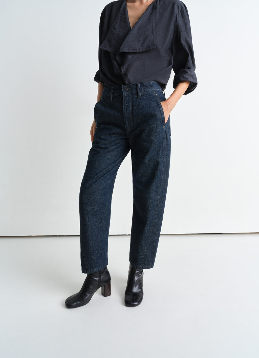Lemaire Twisted Pants in Deep Indigo Heavy Denim, model shot, porte side view twisted seams