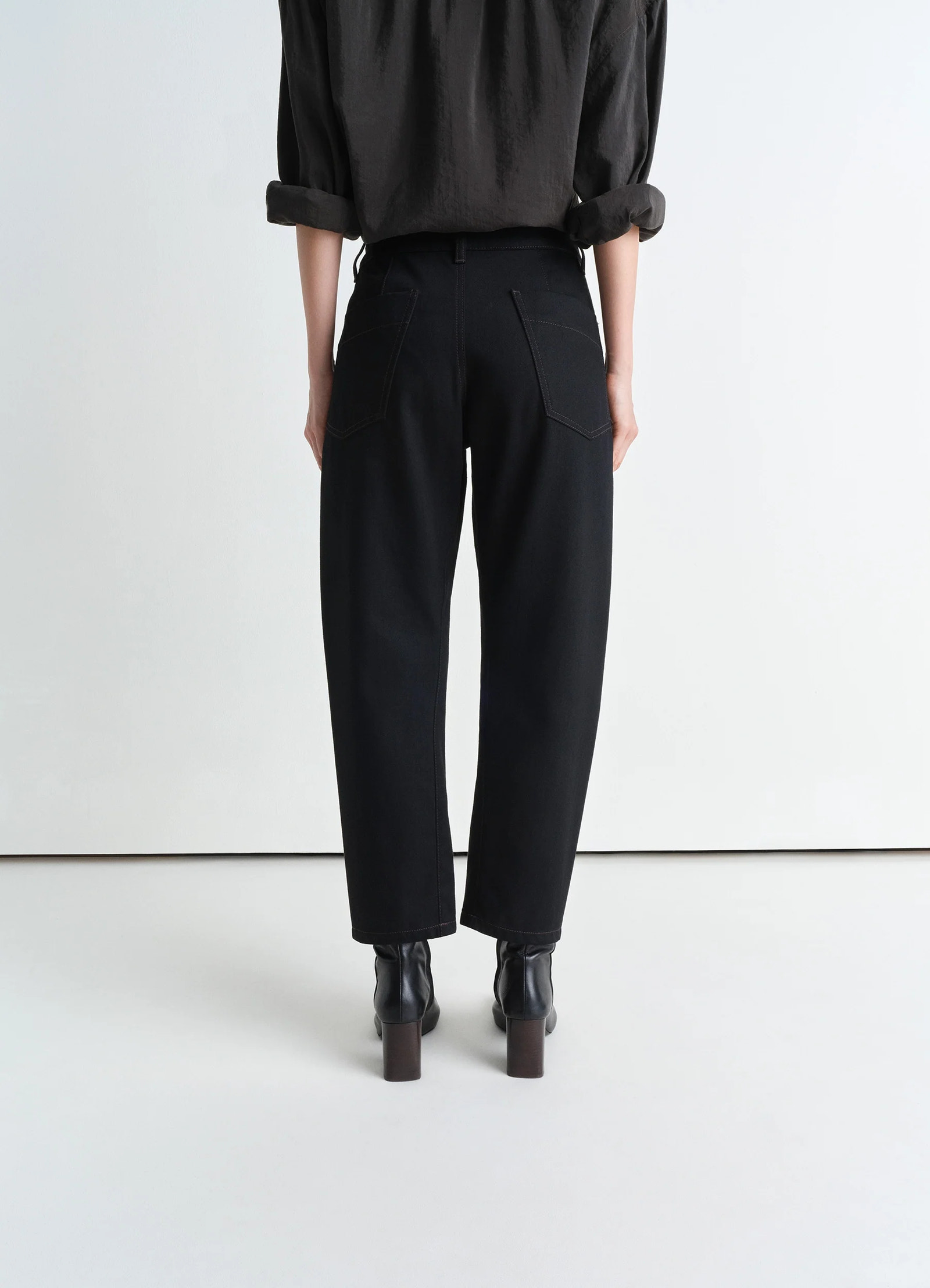 Lemaire twisted pants in deep black heavy denim, model shot, back view high waist classic fit