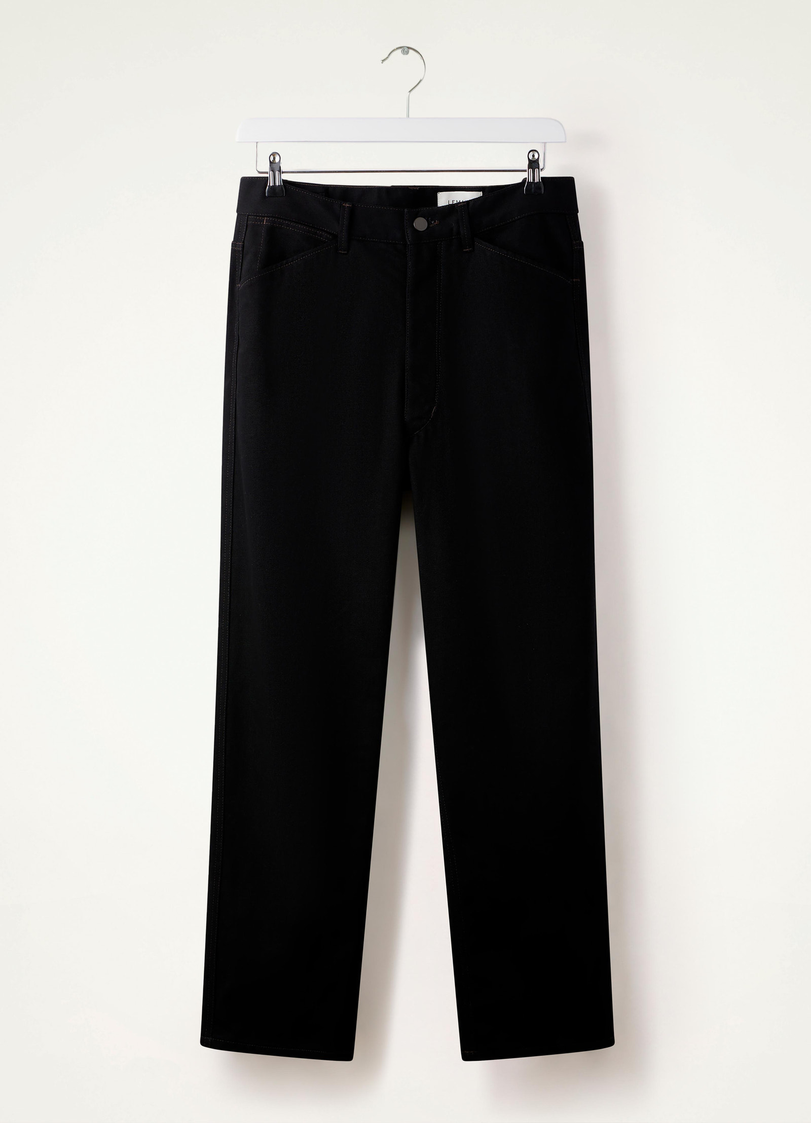 Lemaire curved 5 pocket pants in deep black heavy denim, product shot, hanging view straight hem flat front