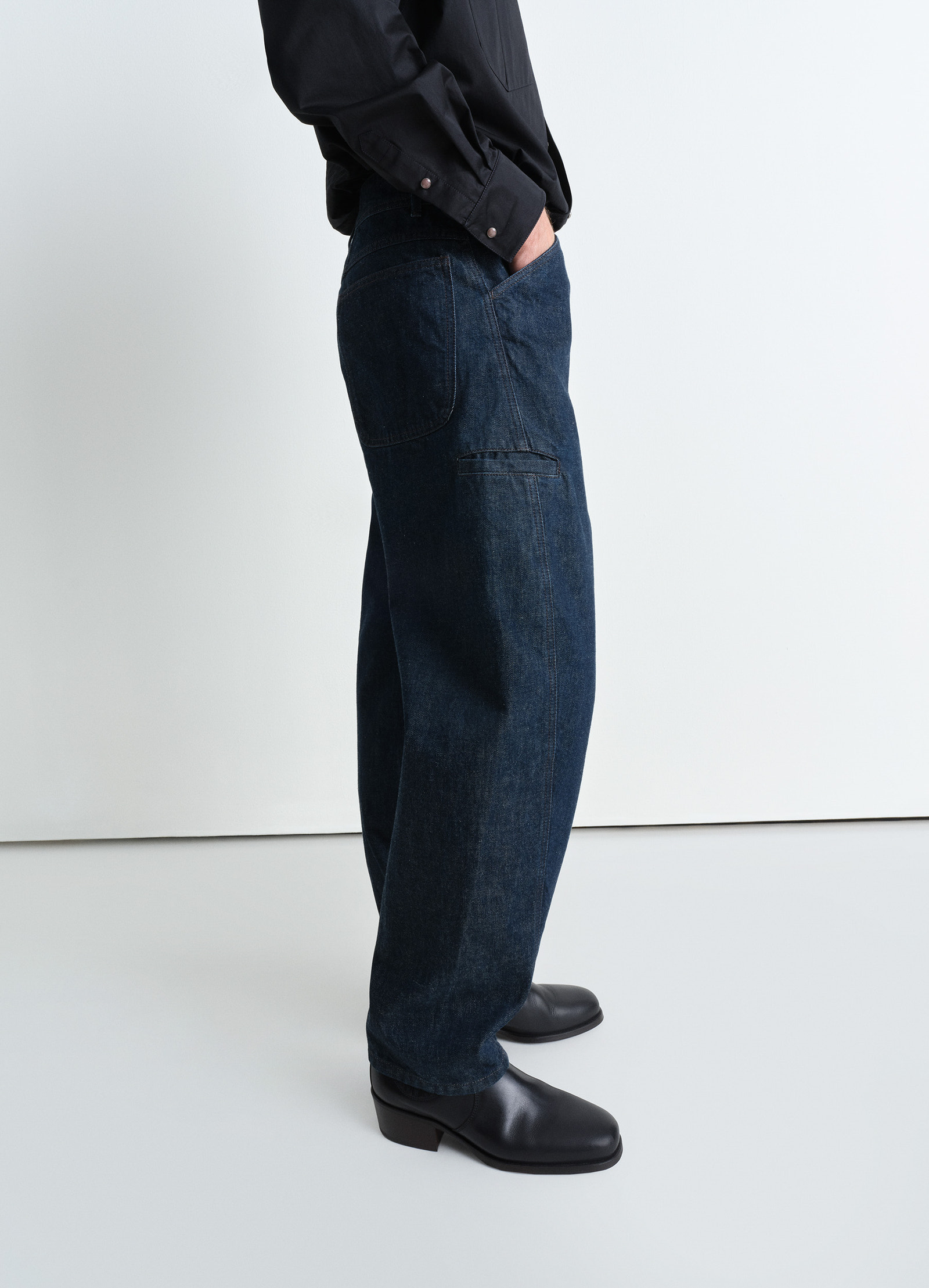 Twisted workwear pants in deep indigo heavy denim, model shot, side view relaxed fit