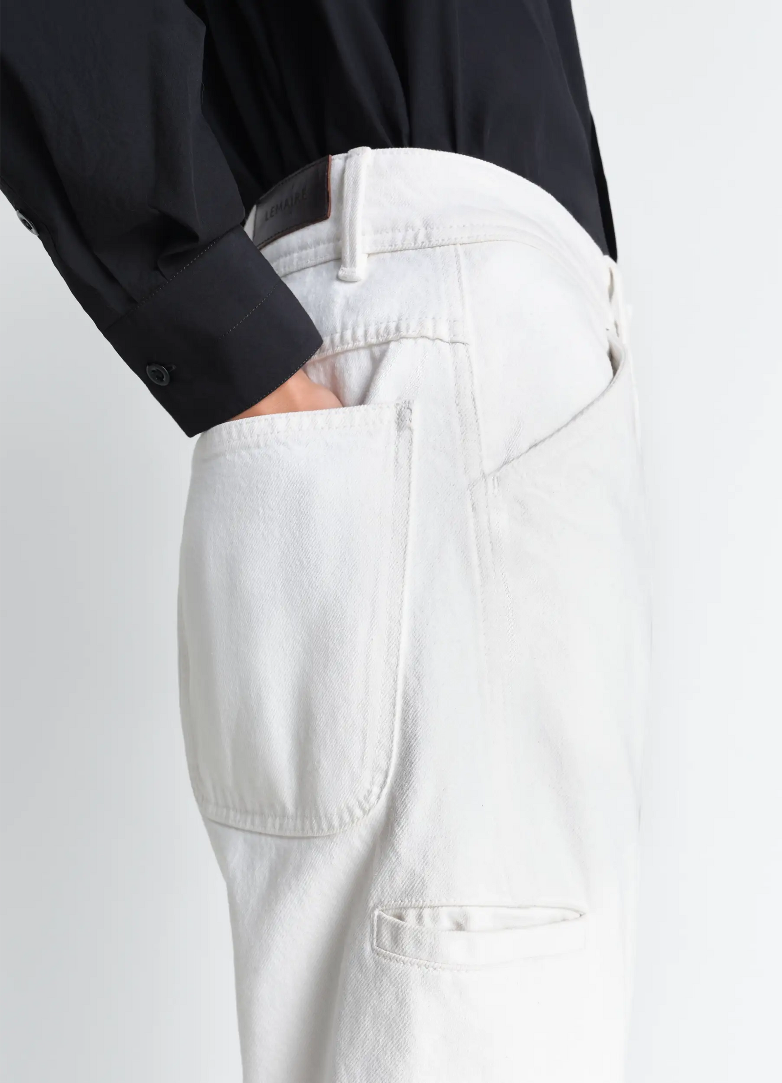Twisted workwear pants in denim, model shot, close-up waist view angled pocket design