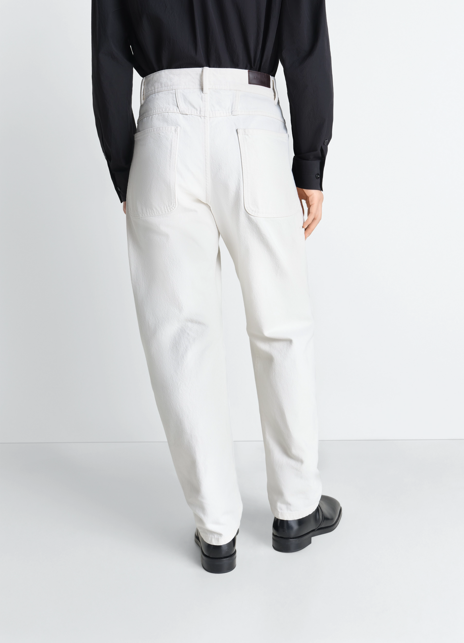 Twisted workwear pants in denim, model shot, back view tapered cuff design