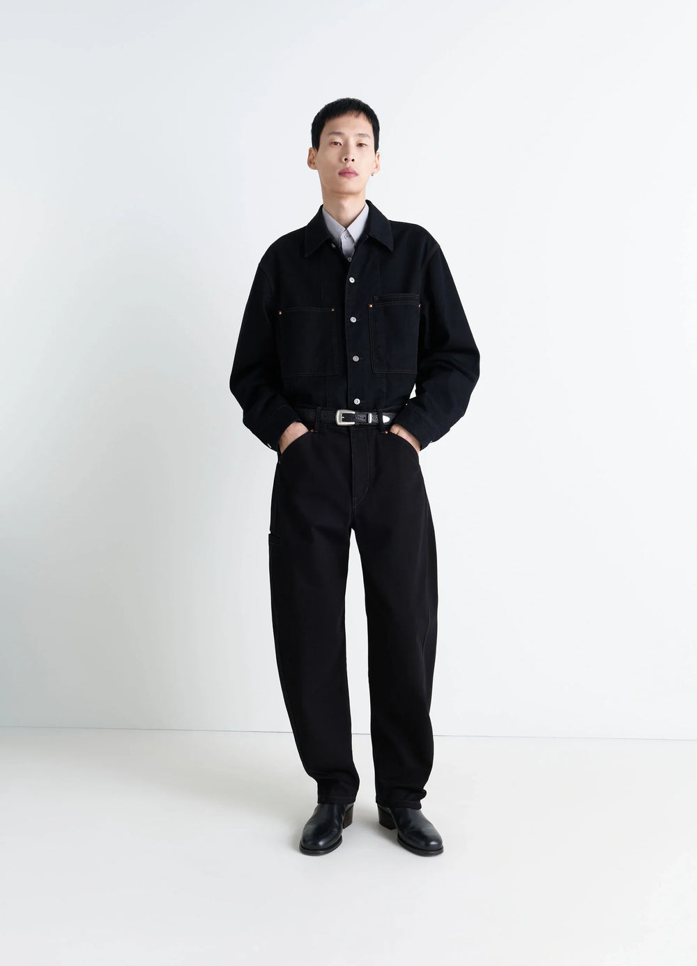 Lemaire Twisted Workwear Pants in Deep Black Thick Denim, model shot, Front view Twisted seams rounded leg