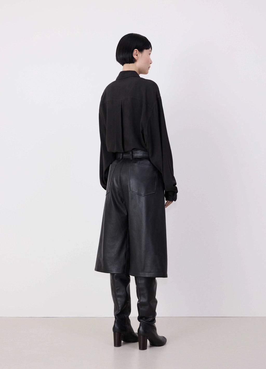 Lemaire Leather Bermuda Shorts in Nappa Cow Leather, model shot, back view long shorts over boots