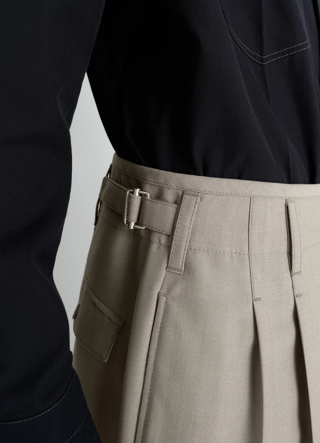 Lemaire Pleated Pants in Tropical wool-blend suiting, model shot, close-up detail pleated design with pocket