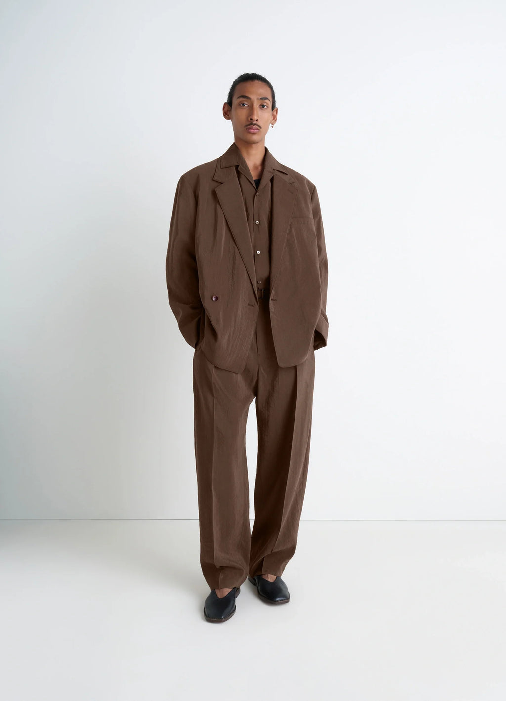 Lemaire Belted Relaxed Pants in Brown Dry Silk Blend, model shot, three-quarter view worn with matching blazer