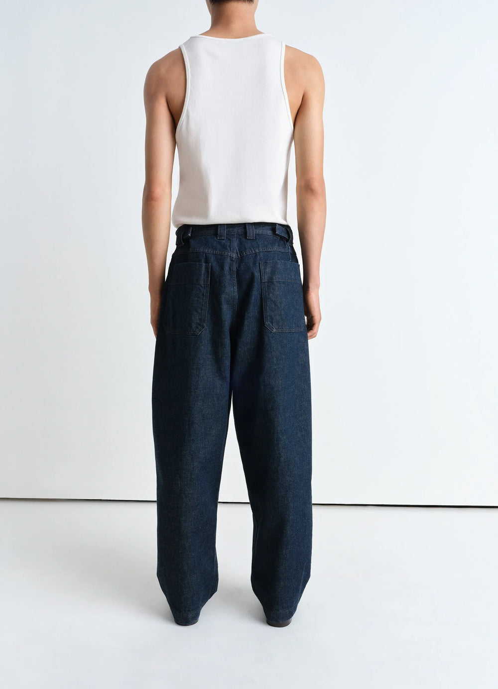 Lemaire Pleated Workwear Pants in Deep Indigo Heavy Denim, model shot, back view back pocket detail