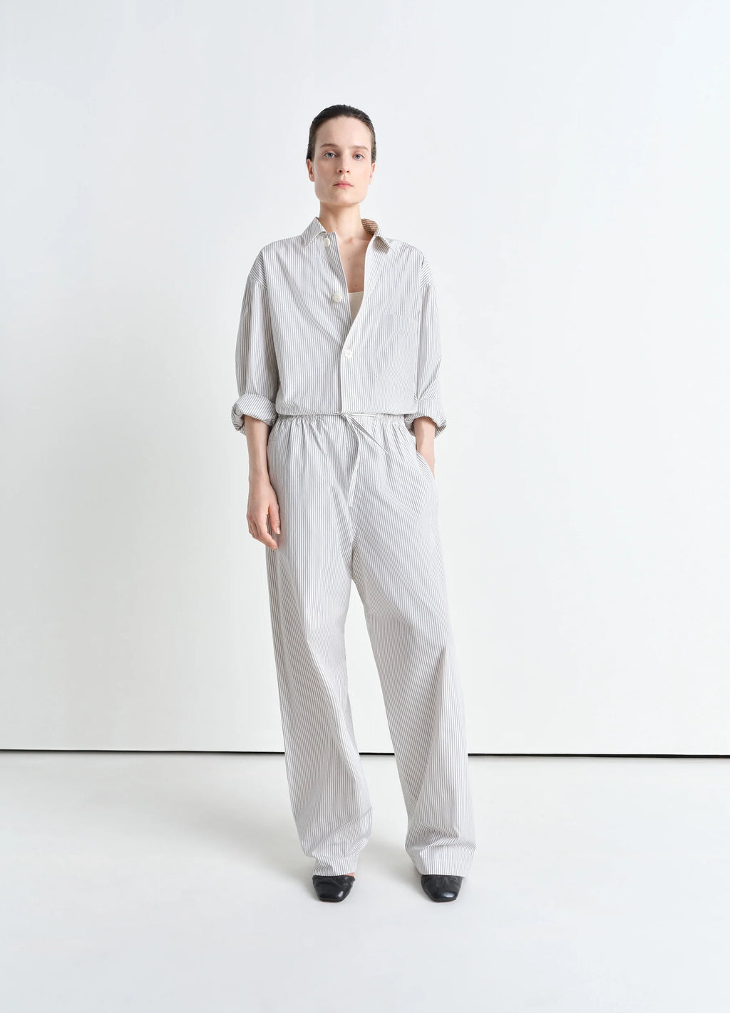 Lemaire Pyjama Pants in Striped Cotton Poplin, model shot, three-quarter view loose fit, cuffed hem