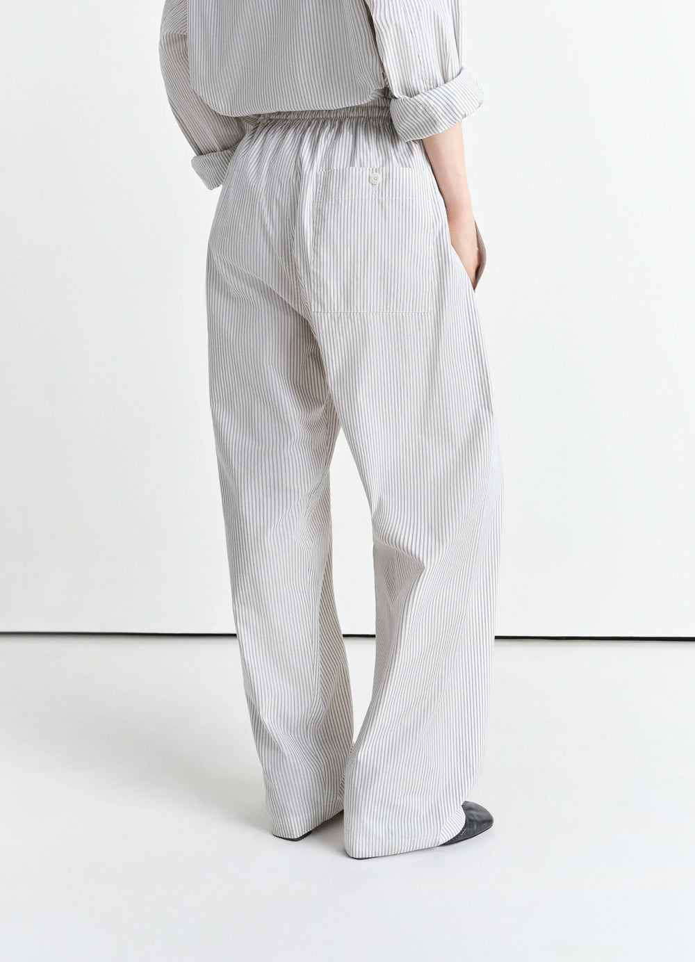 Lemaire Pyjama Pants in Striped Cotton Poplin, model shot, rear three-quarter view high-rise elastic waist