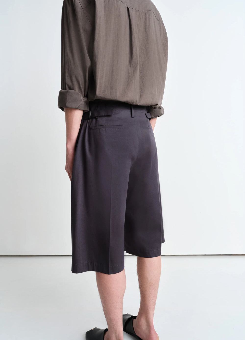 Lemaire Maxi Pleated Bermuda in Grey compact cotton twill, model shot, back view cropped hem, belt loops