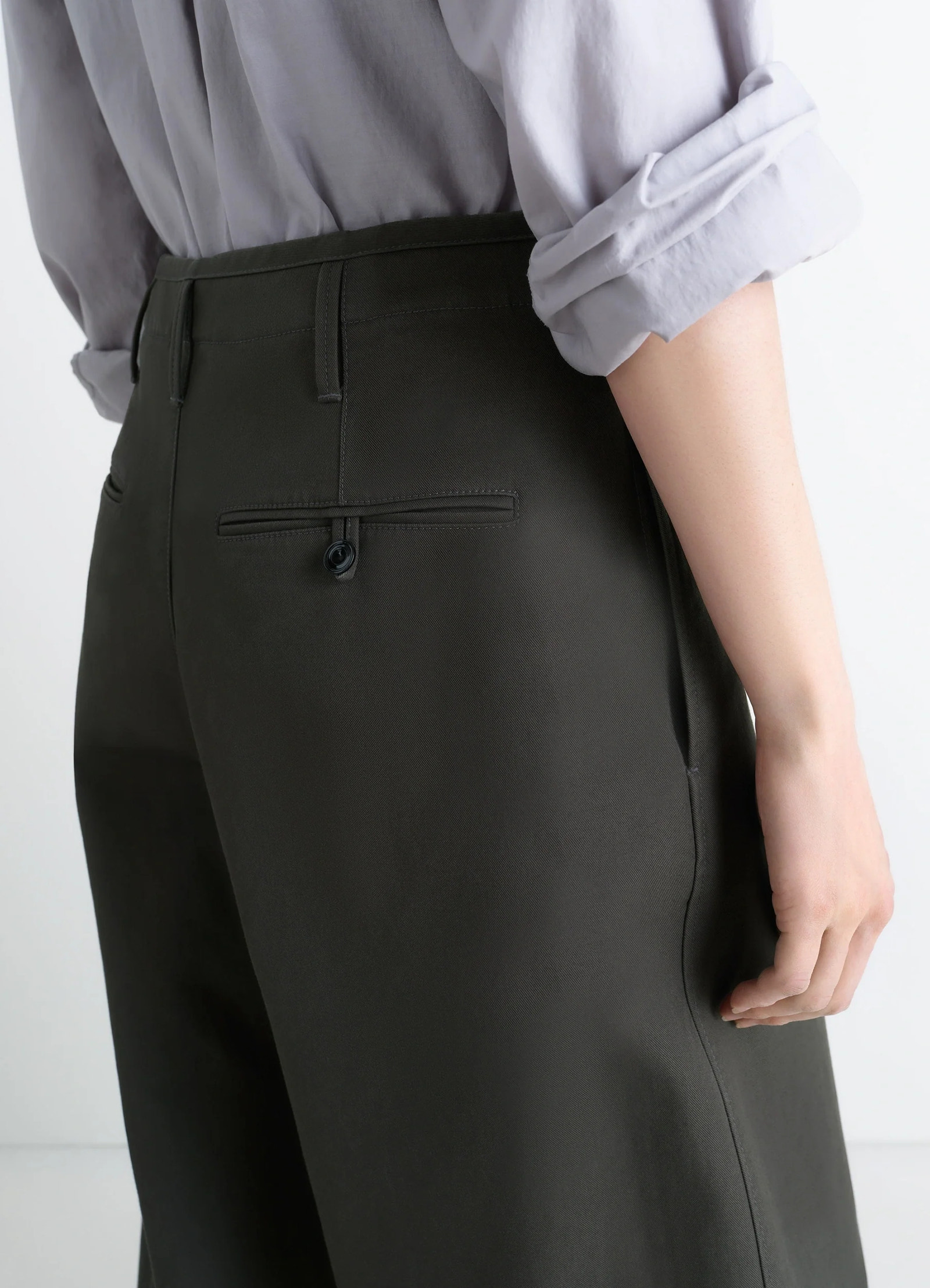 Lemaire large chino pants in dark olive cotton twill, model shot, close-up side detail rear welt pocket visible