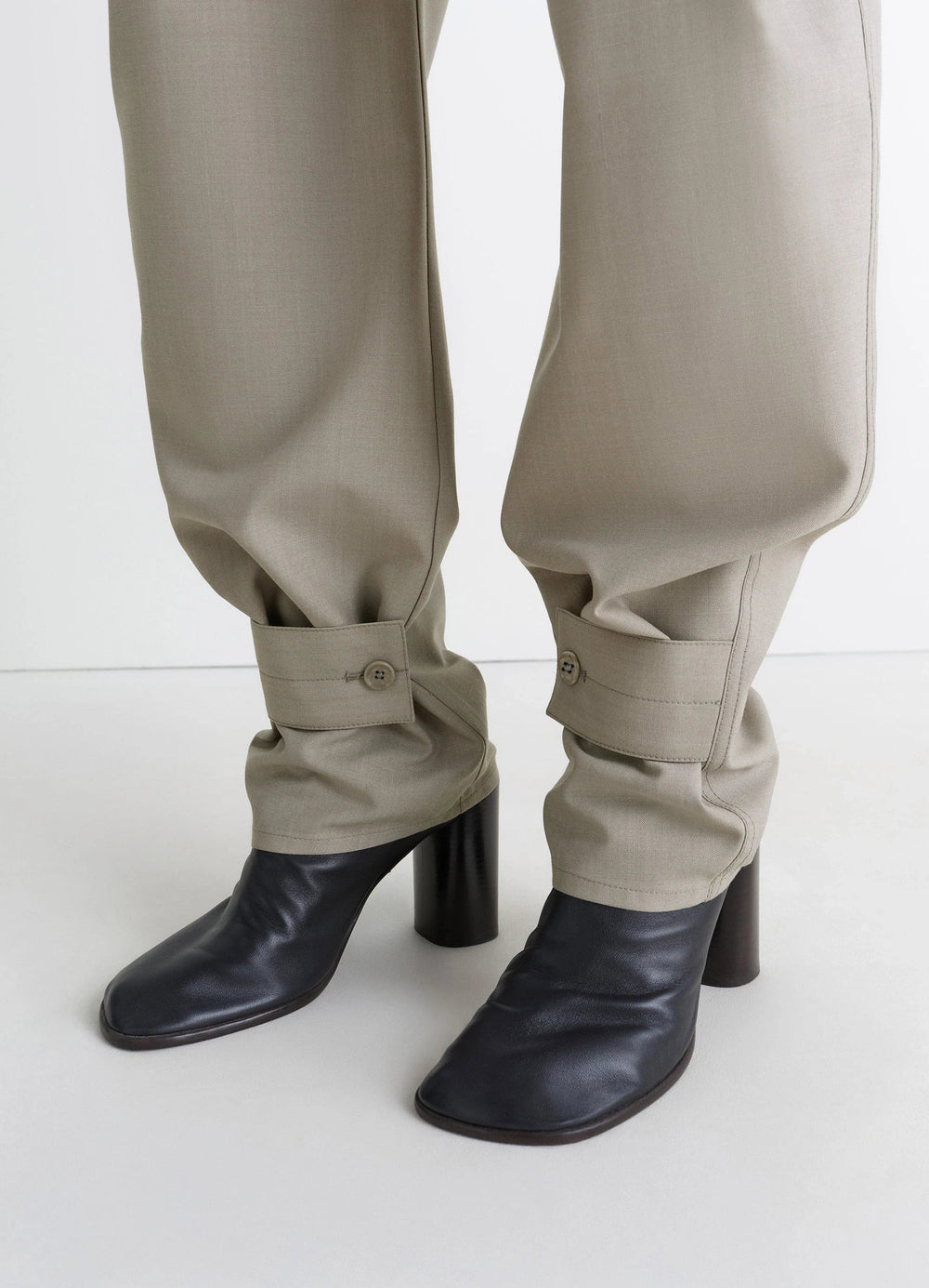 Lemaire Curved Tailored Pants in Tropical Wool Blend, model shot, detail shot belted cuff close-up